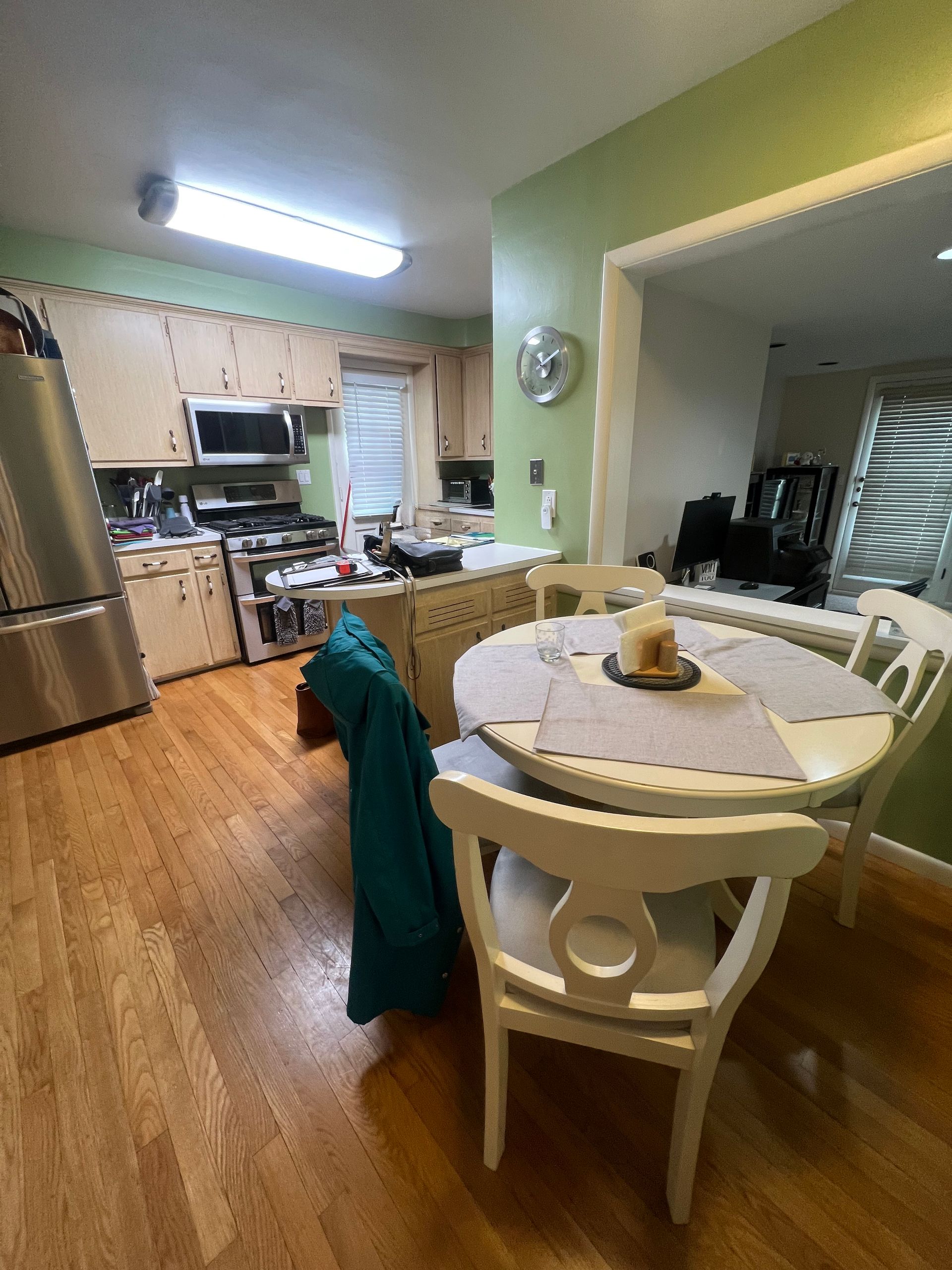 A kitchen with would cabinets, cramped layout and stainless steel appliances.