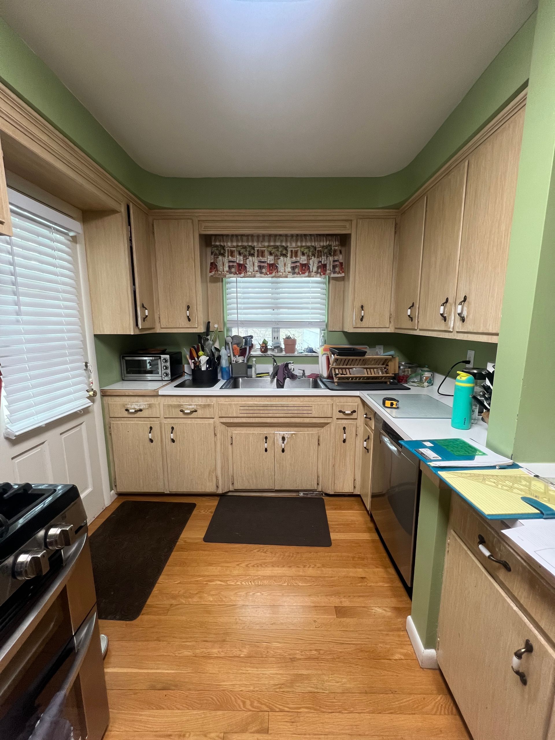 A kitchen with wood cabinets , a sink, and a window.