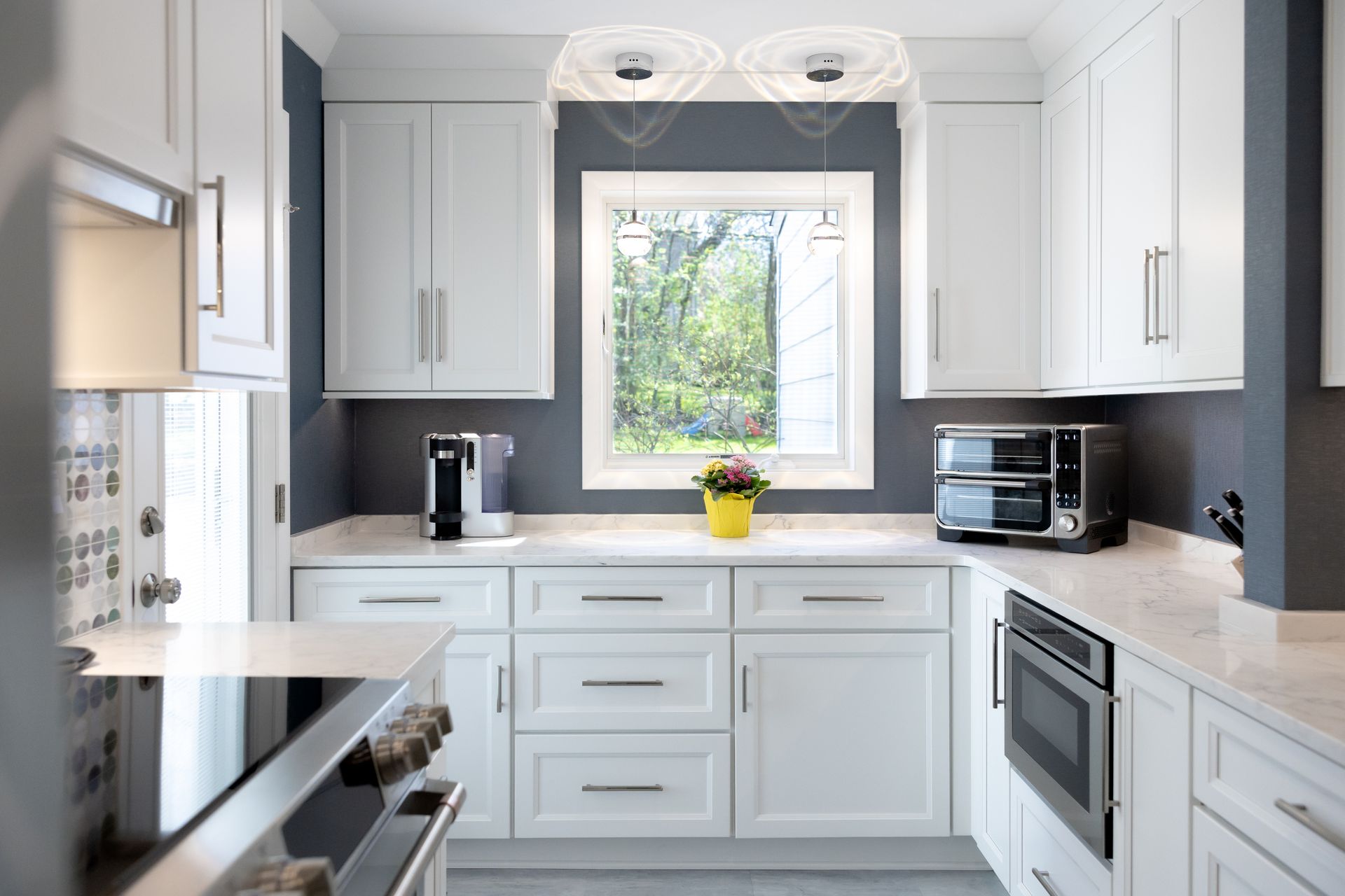 A kitchen with white cabinets and stainless steel appliances