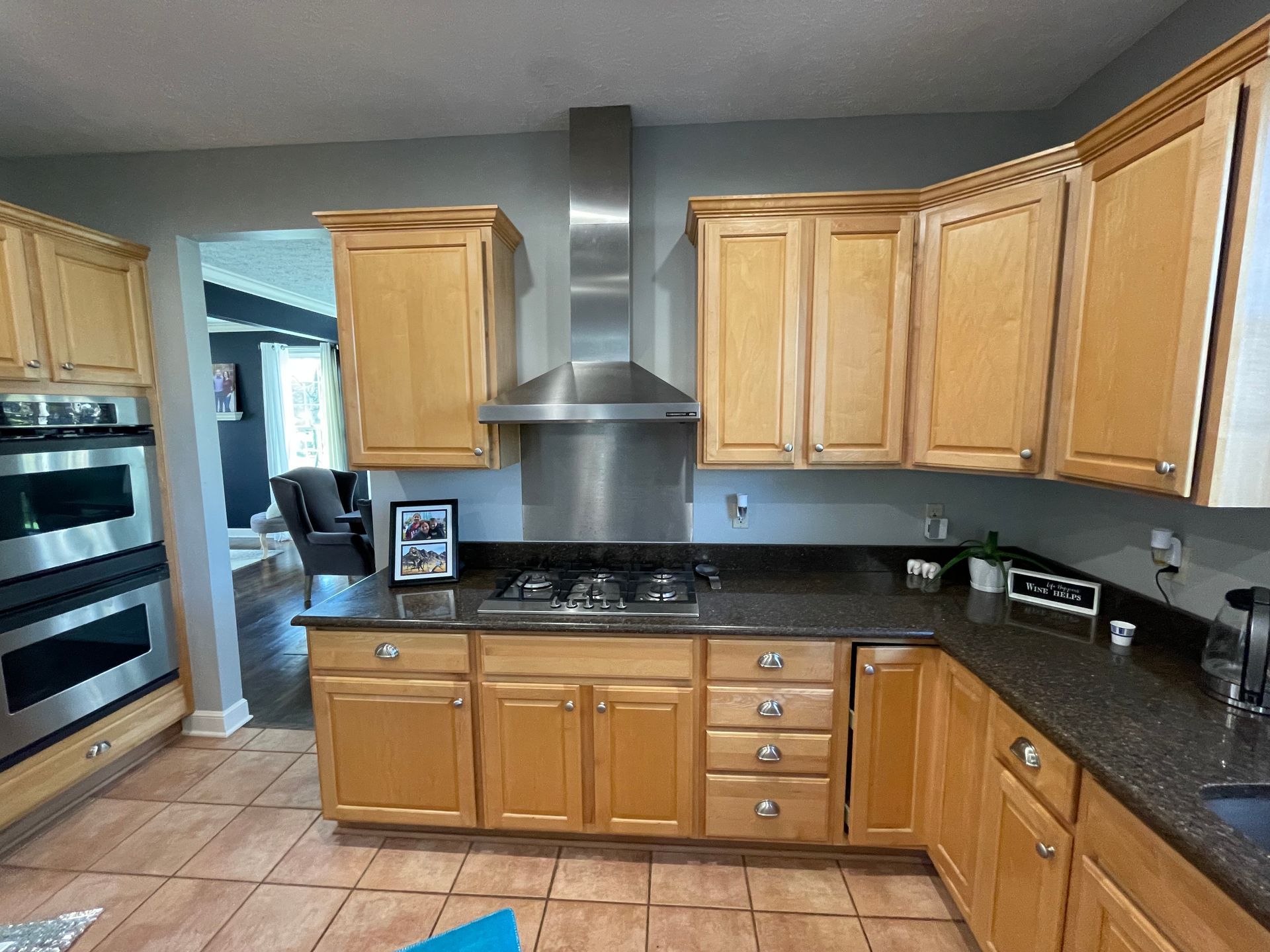 A wood kitchen with dark black countertops