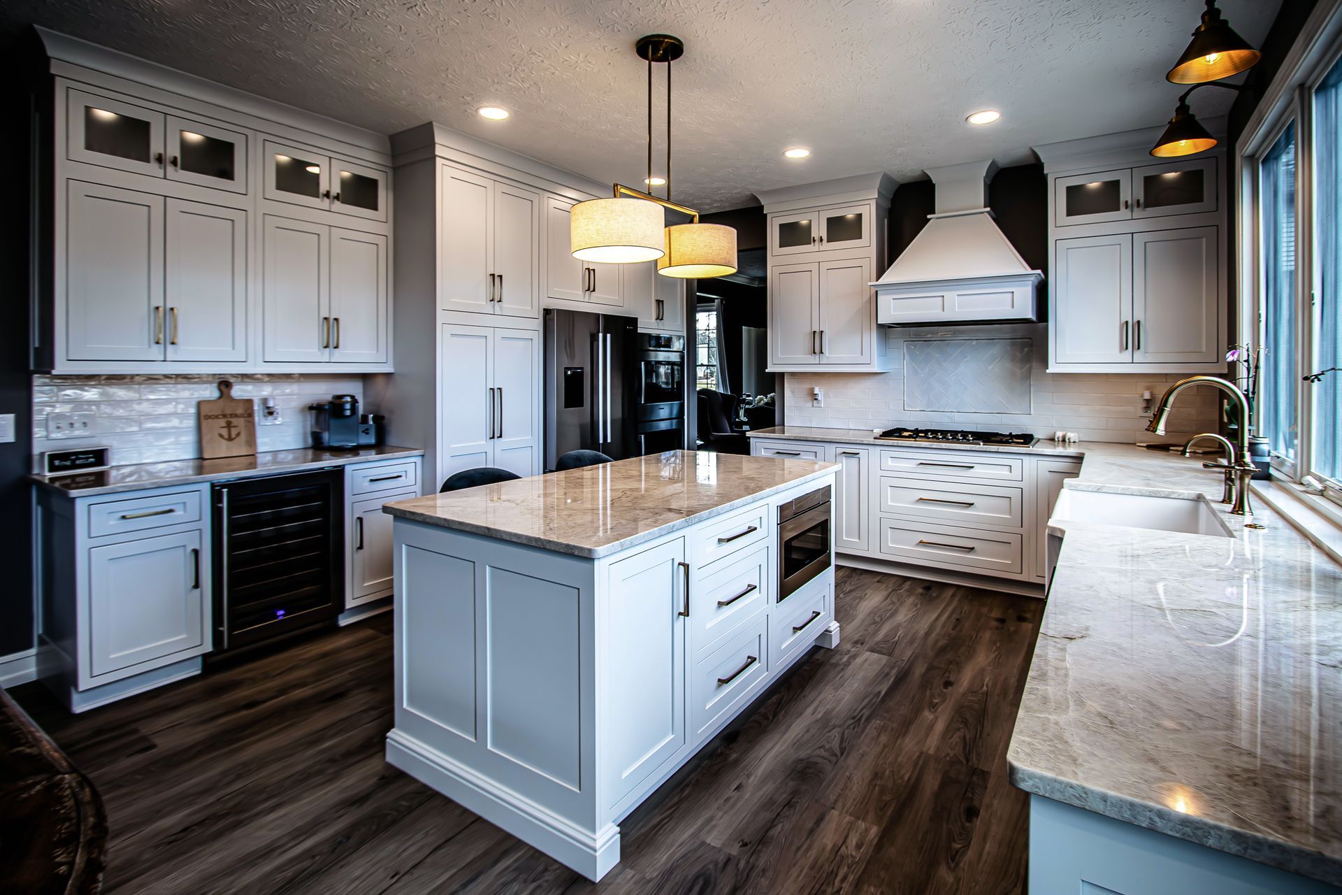 A kitchen with white cabinets and a large island in the middle.