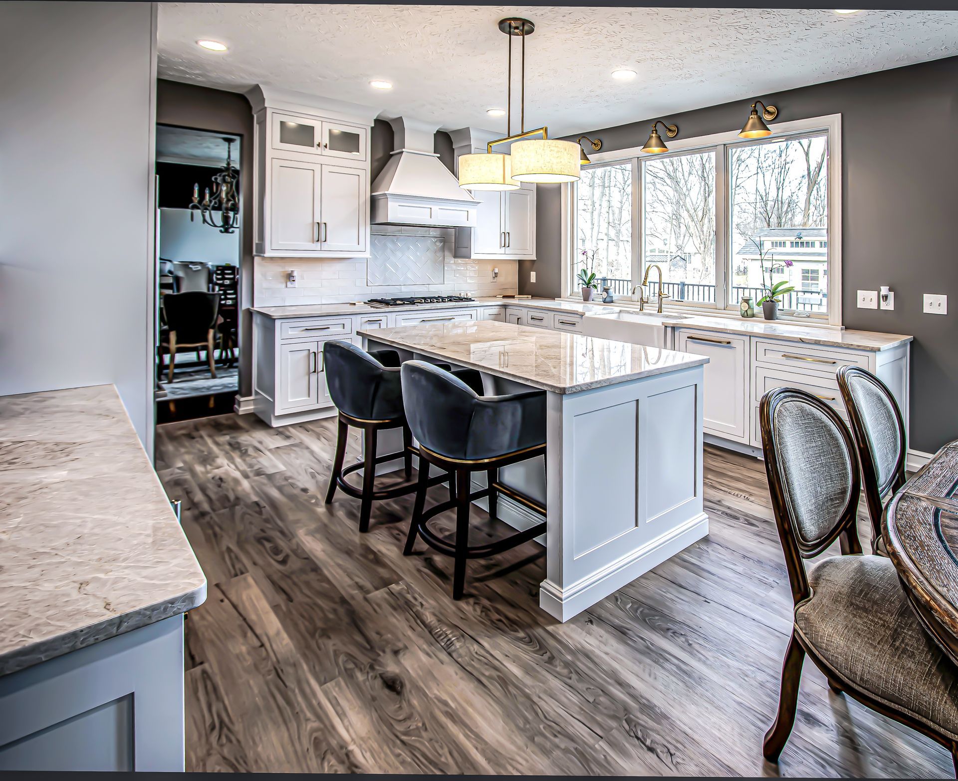 A kitchen with white cabinets and a large island in the middle