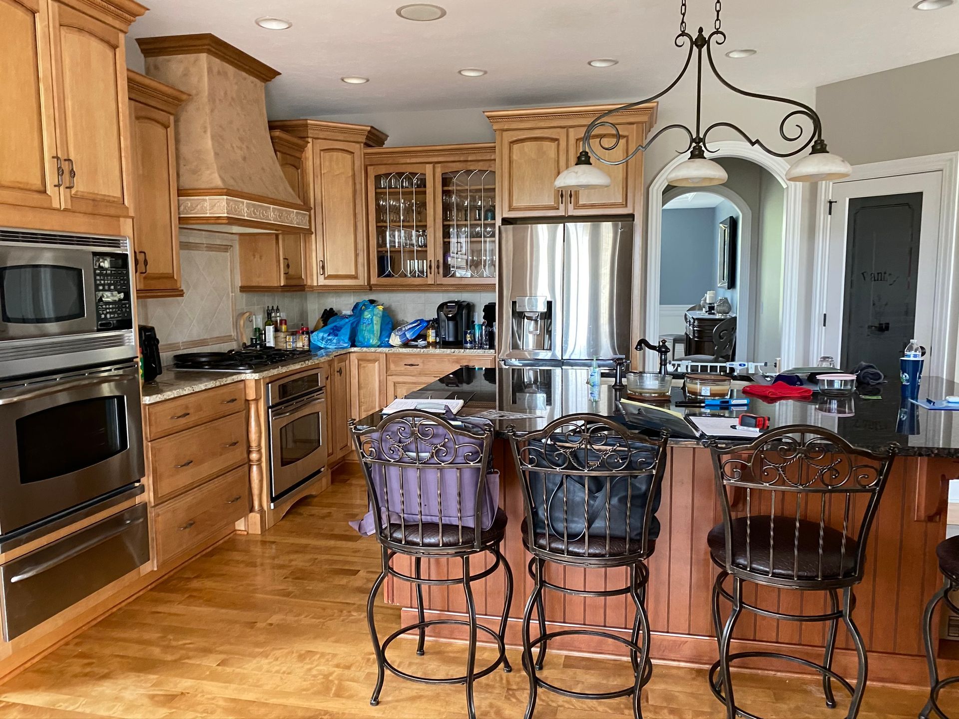 A kitchen with wooden cabinets , stainless steel appliances , and a large island.