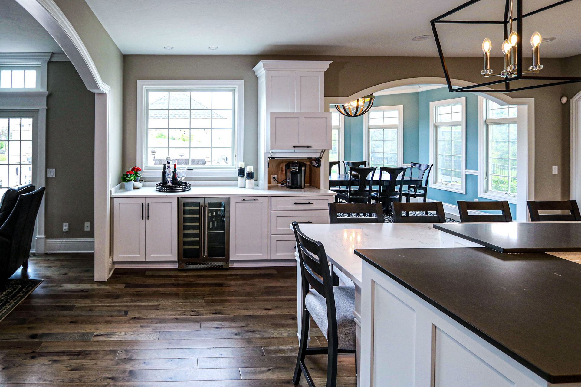 A kitchen with white cabinets and a large island in the middle