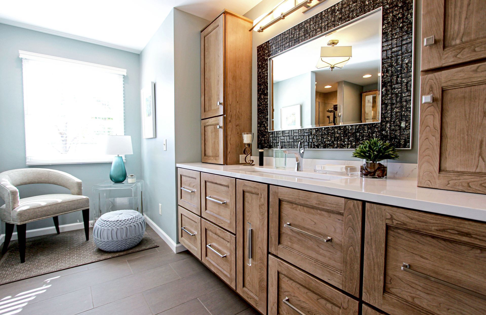 A bathroom with a large mirror and wooden cabinets.