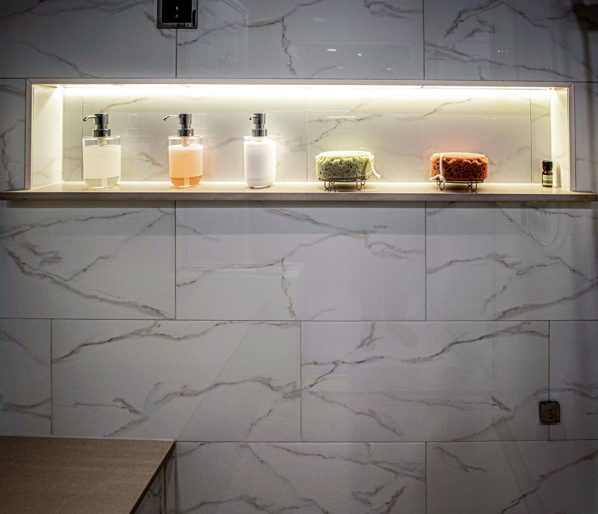 A bathroom with a shelf with bottles of soap on it