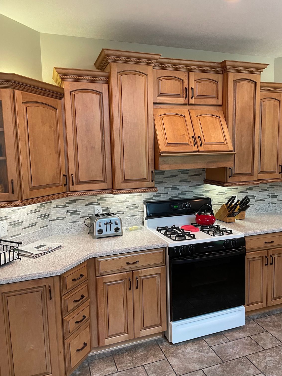 A kitchen with wooden cabinets and a stove.