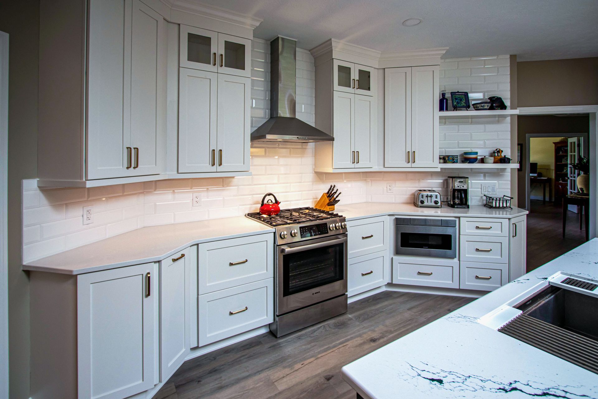 A kitchen with white cabinets , stainless steel appliances , and a sink.