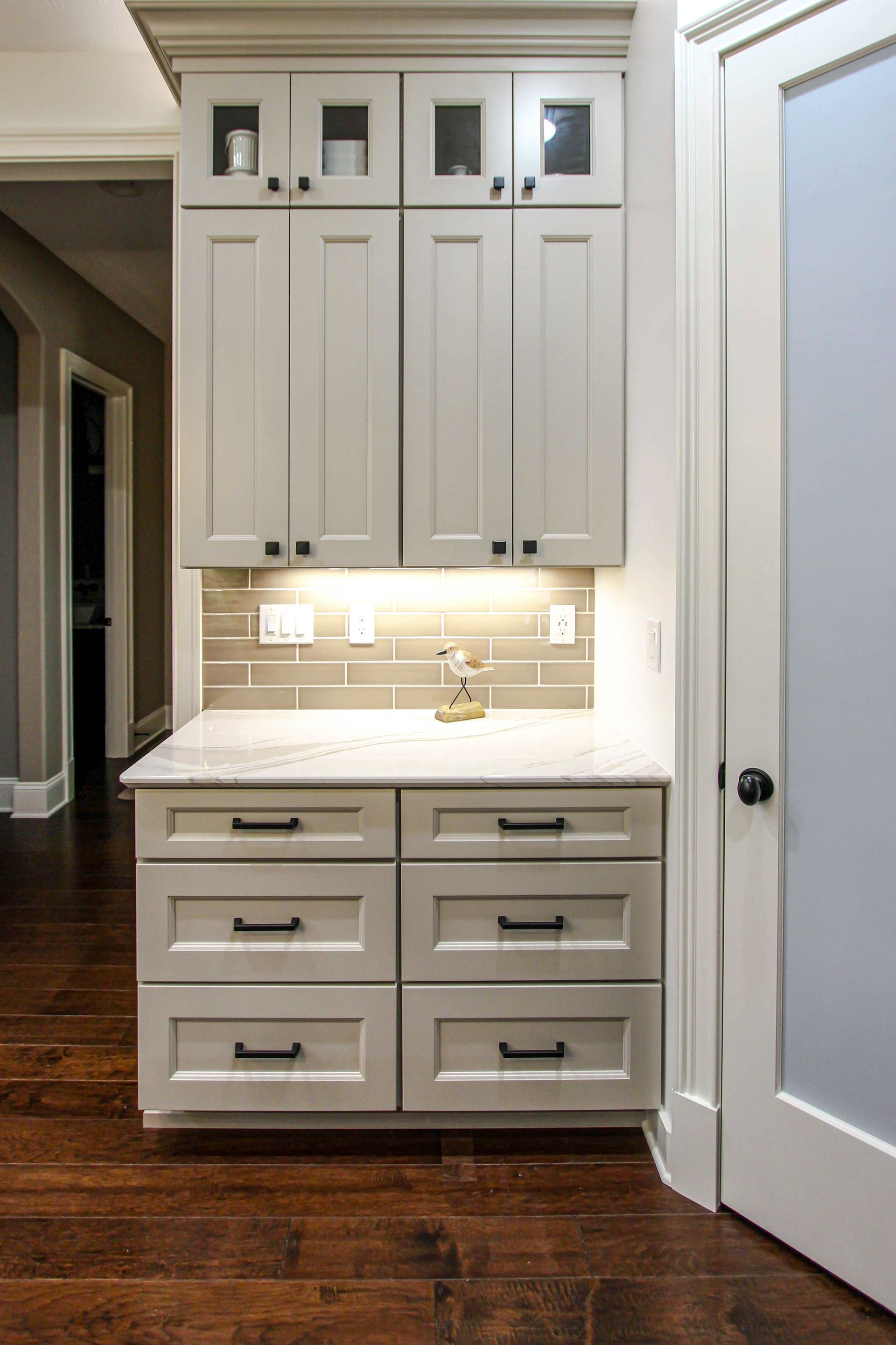 A kitchen with white cabinets and drawers and a sink.