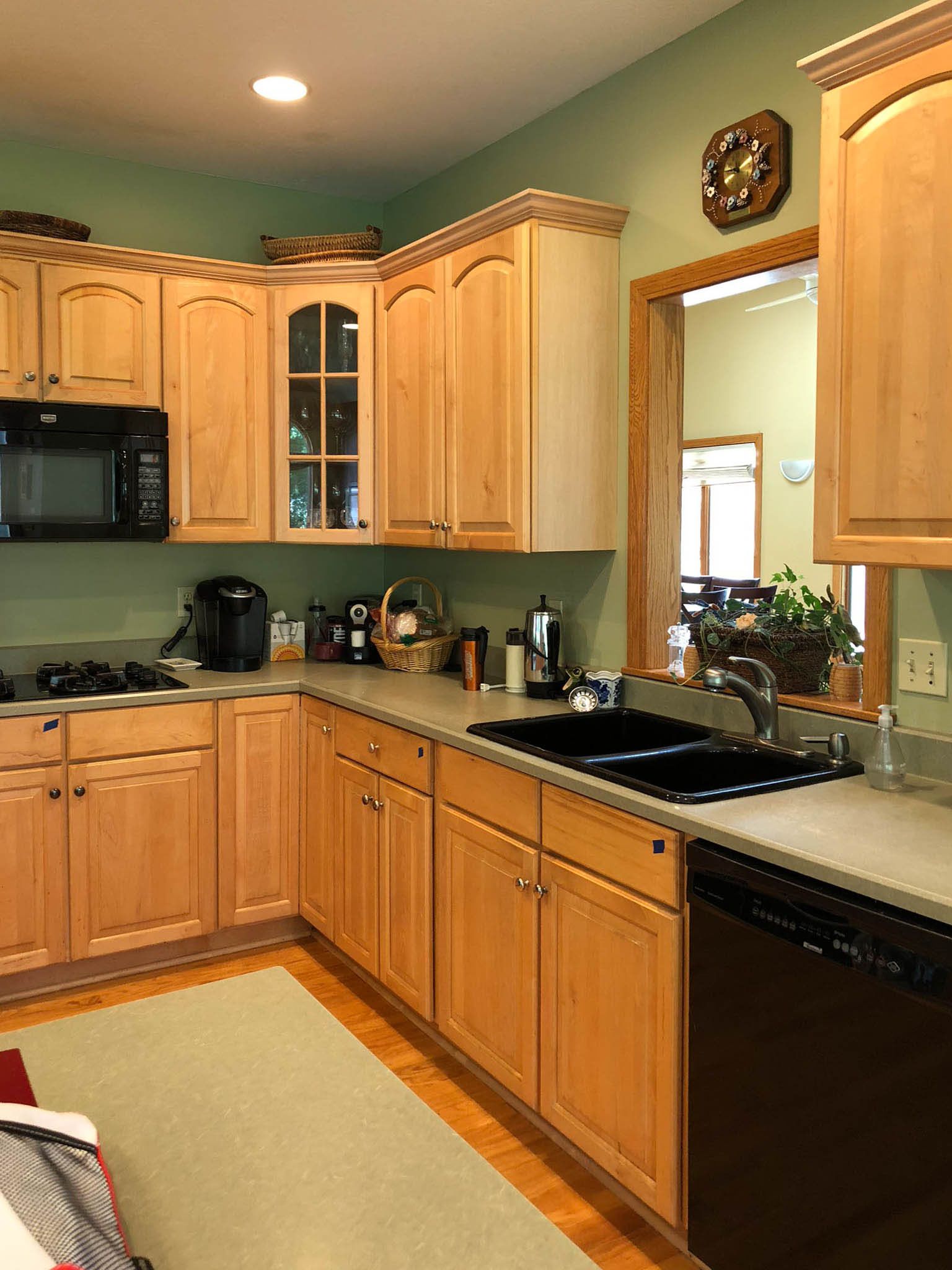 A kitchen with wooden cabinets and a black dishwasher