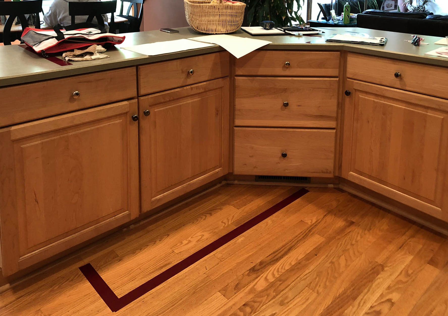 A kitchen with wooden cabinets and a red line on the floor