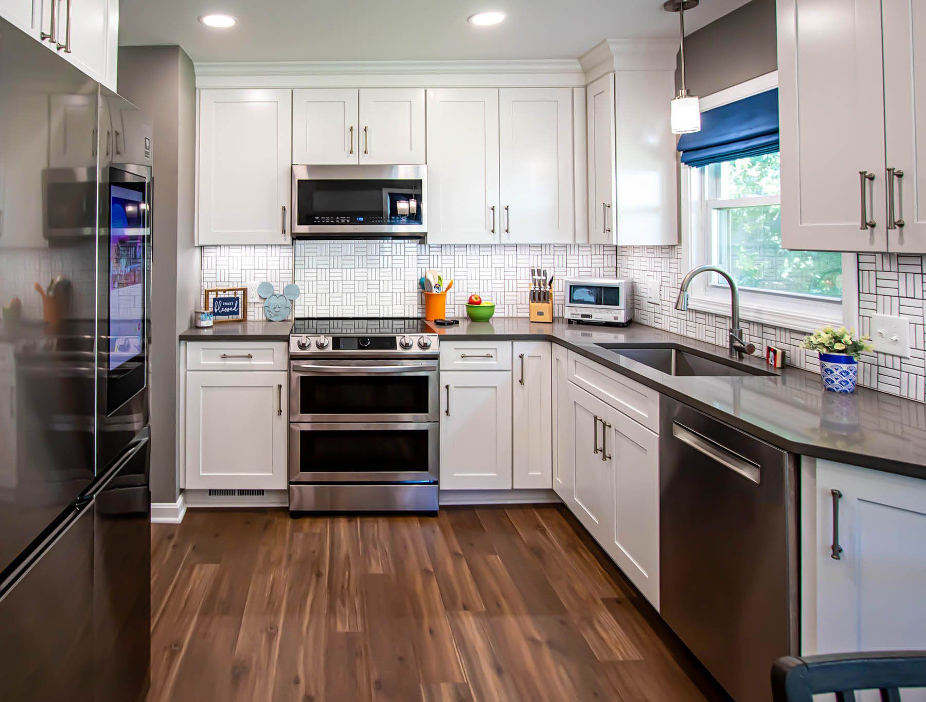 A kitchen with white cabinets and stainless steel appliances.