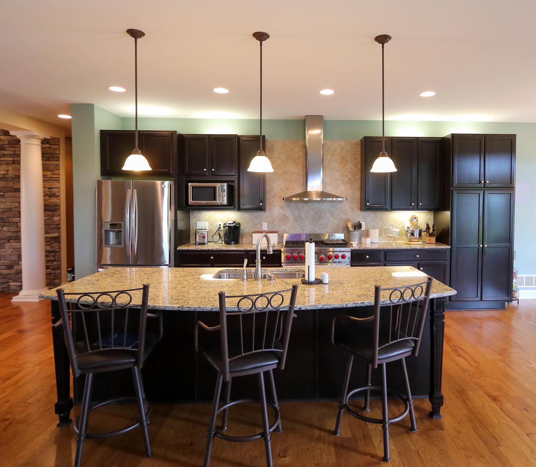 A kitchen with granite counter tops and black cabinets