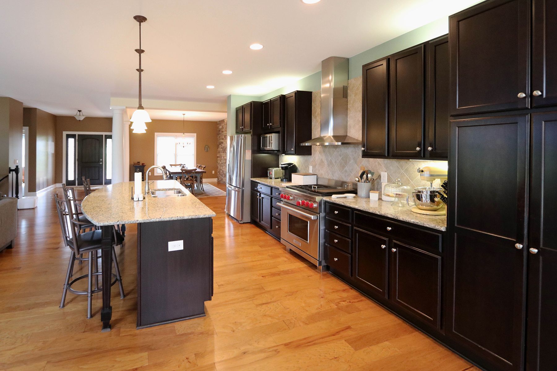 A kitchen with black cabinets and stainless steel appliances