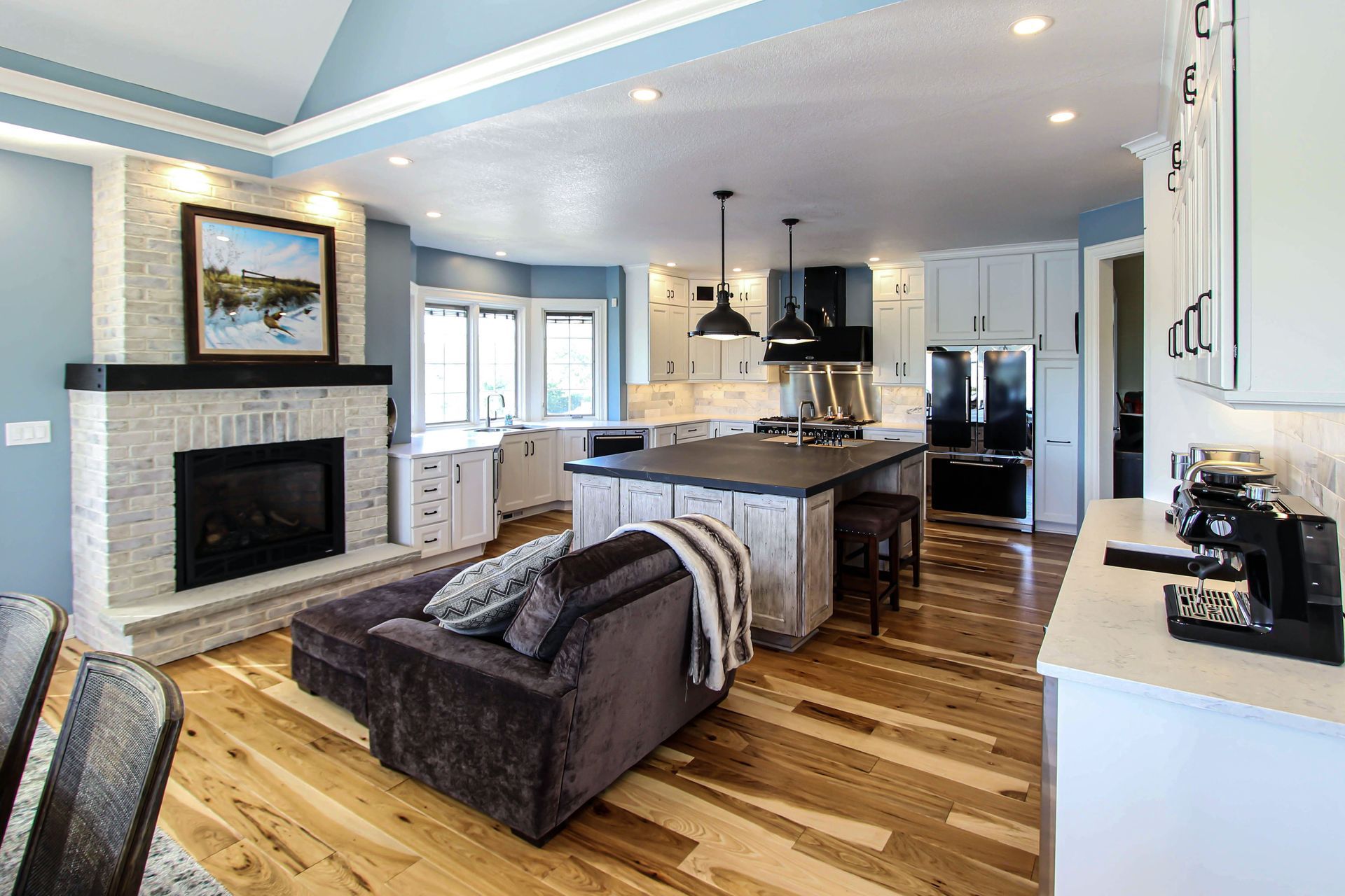 A living room with a couch , fireplace , and kitchen.