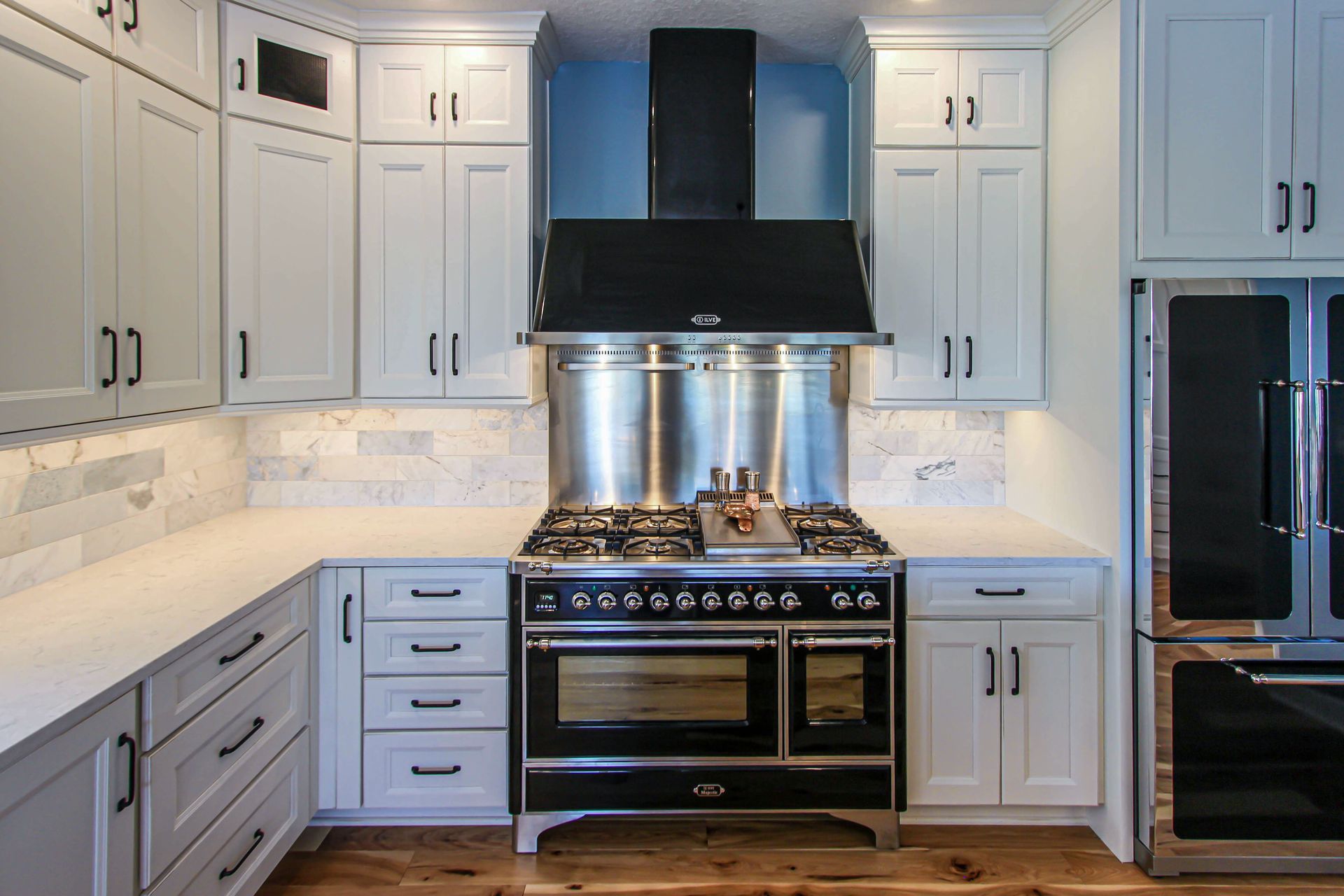 A kitchen with white cabinets and stainless steel appliances