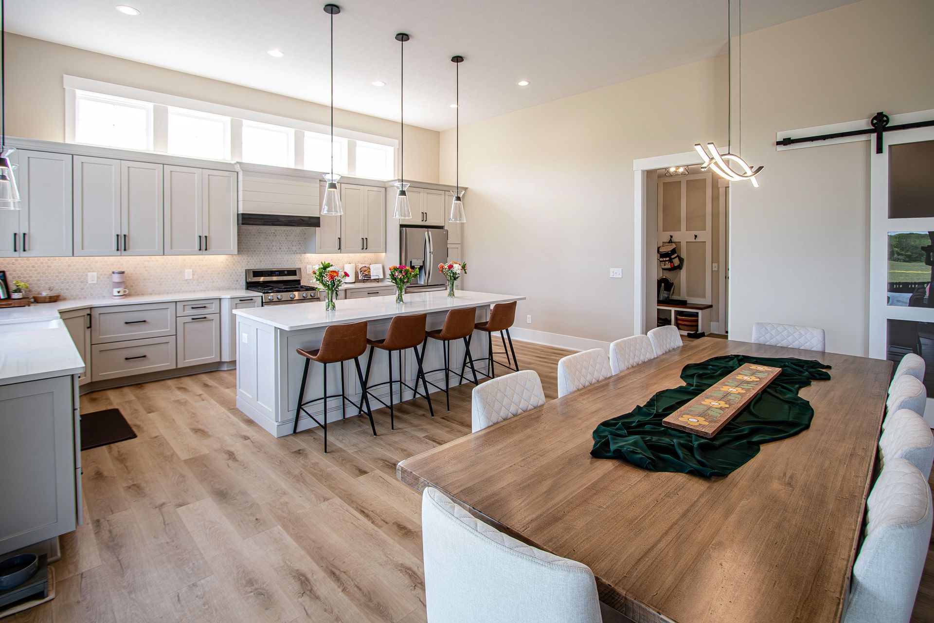 A kitchen and dining room in a house with a long wooden table.