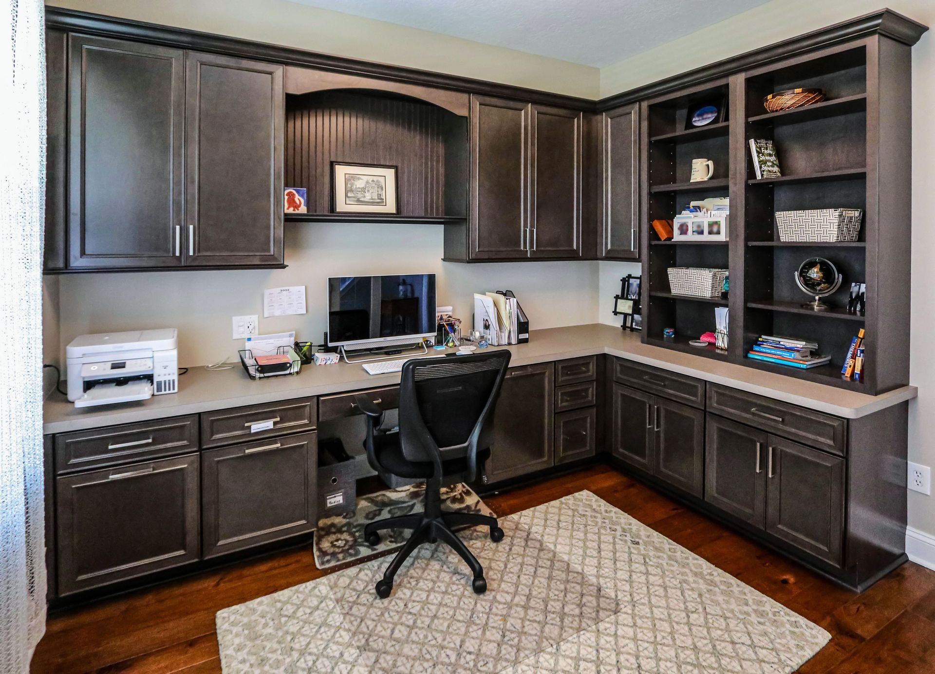 A home office with a desk , chair , computer and printer.