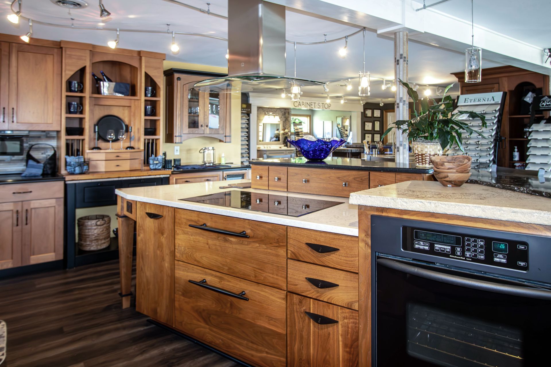 A kitchen with wooden cabinets , stainless steel appliances and a large island.