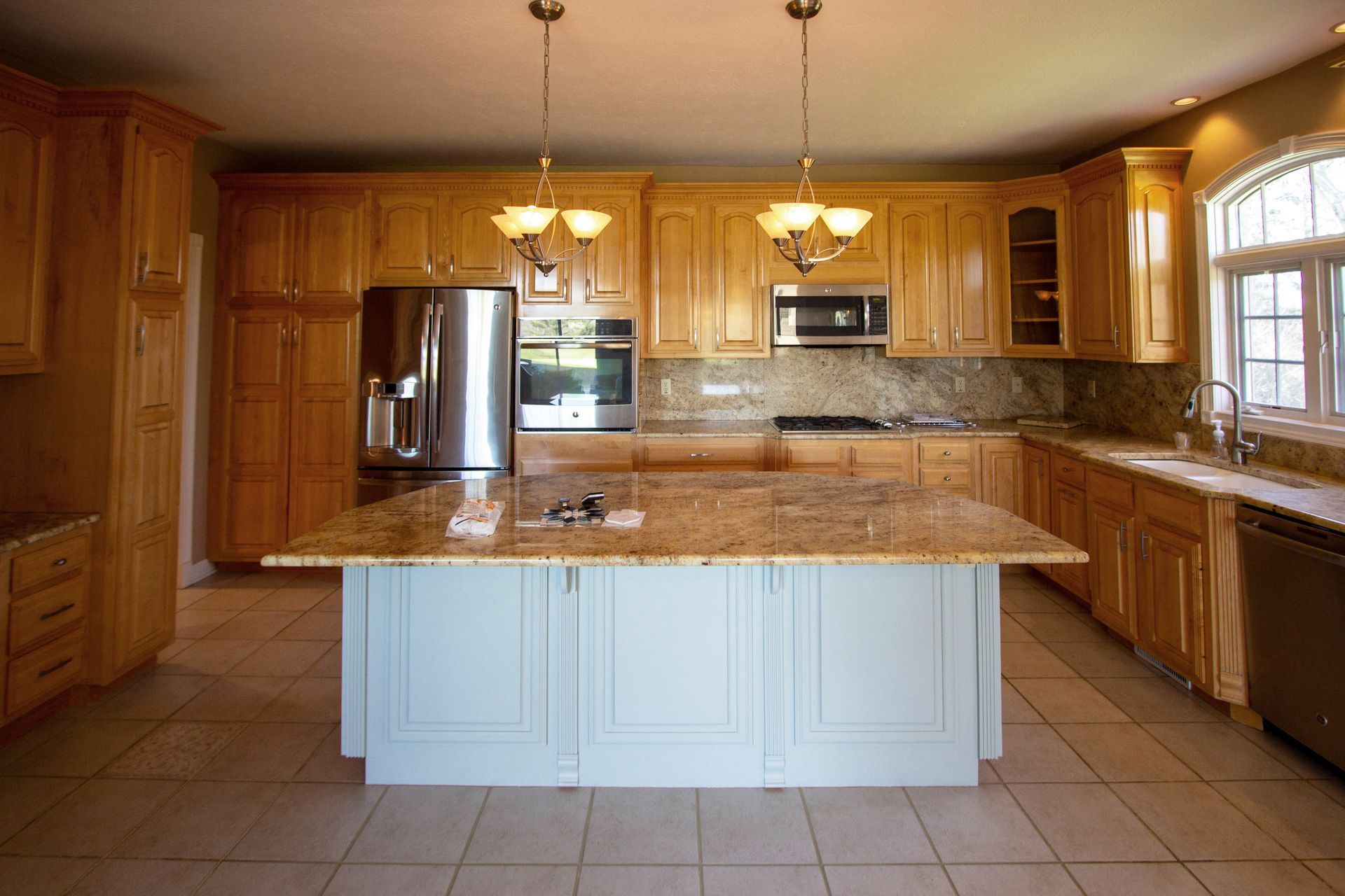 An empty kitchen with a large island in the middle