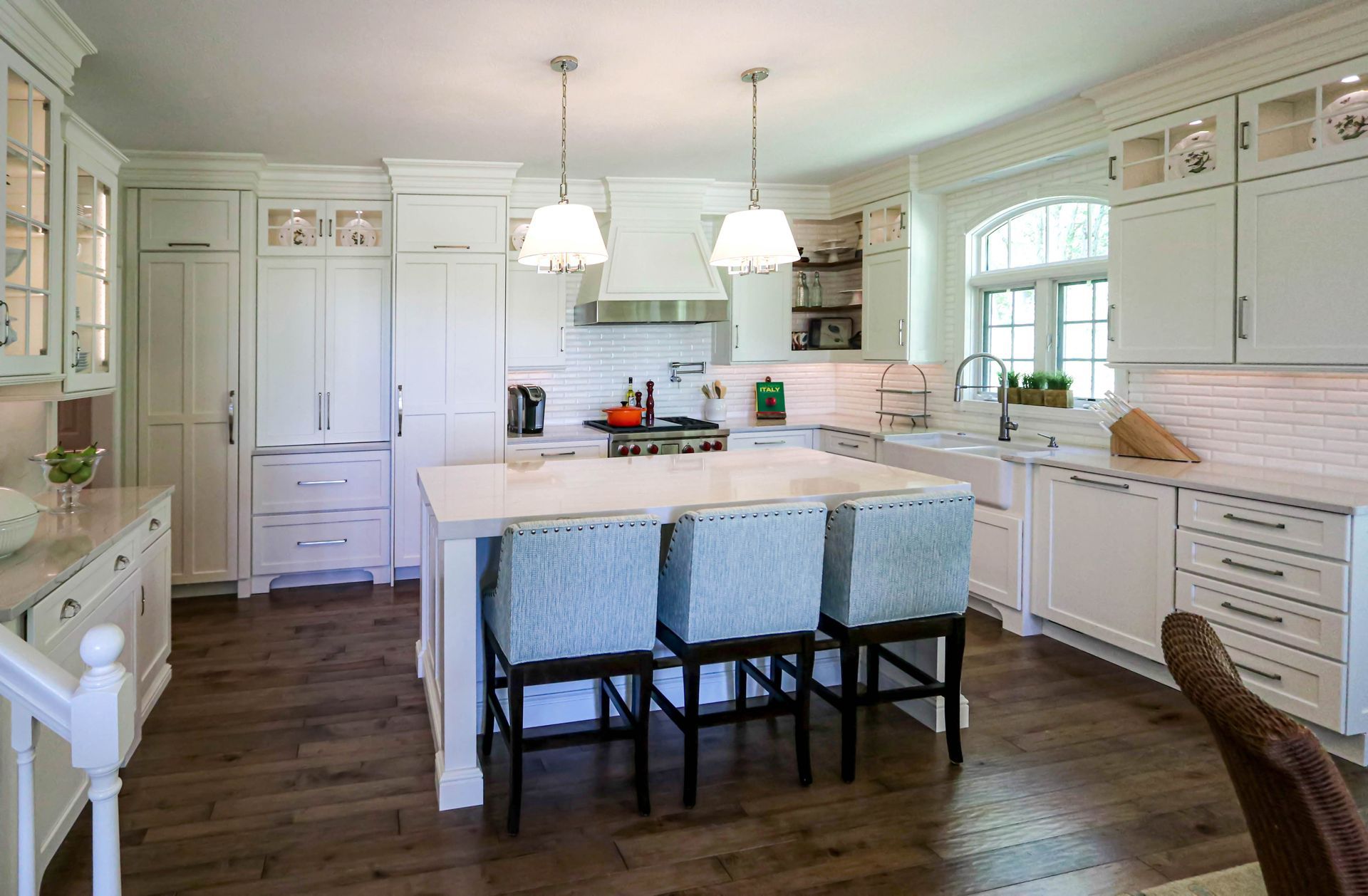 A kitchen with white cabinets and a large island