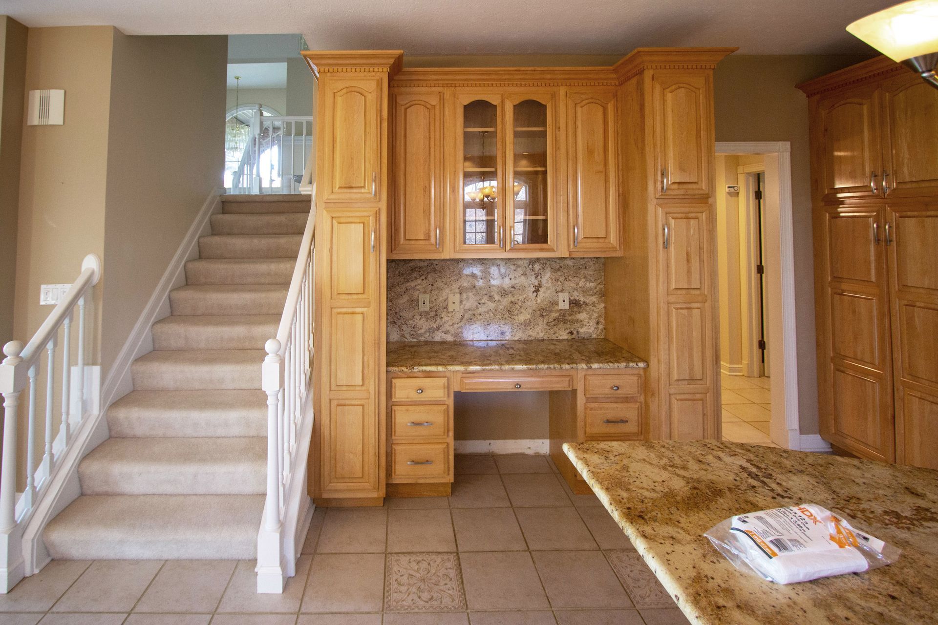 A kitchen with stairs leading up to the second floor