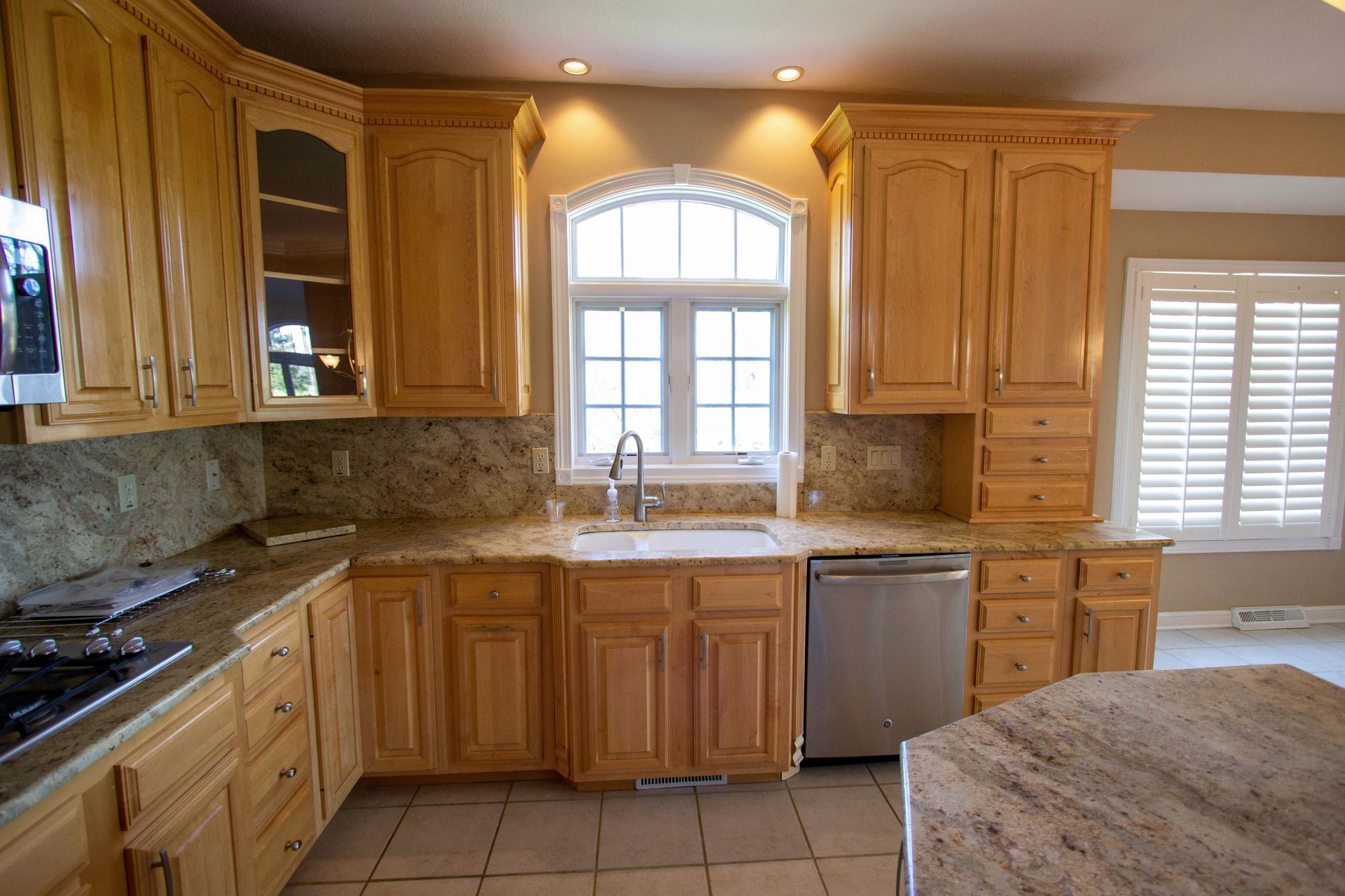 A kitchen with wooden cabinets and granite counter tops.
