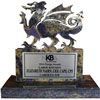 A statue of a dragon is sitting on top of a marble base.