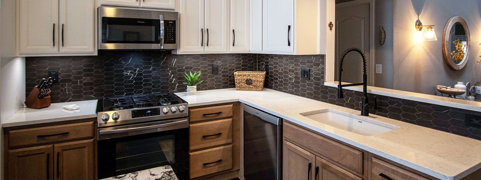 A kitchen with stainless steel appliances , wooden cabinets , a sink , and a microwave.
