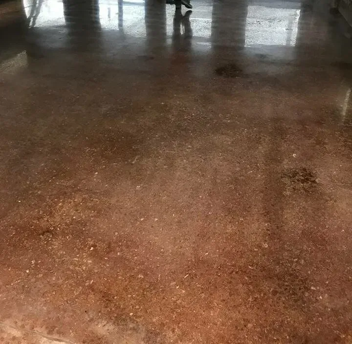 Polished, reddish-brown concrete floor reflecting light.