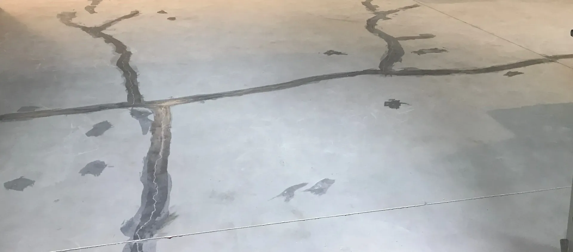 A close up of a concrete floor with cracks in it.