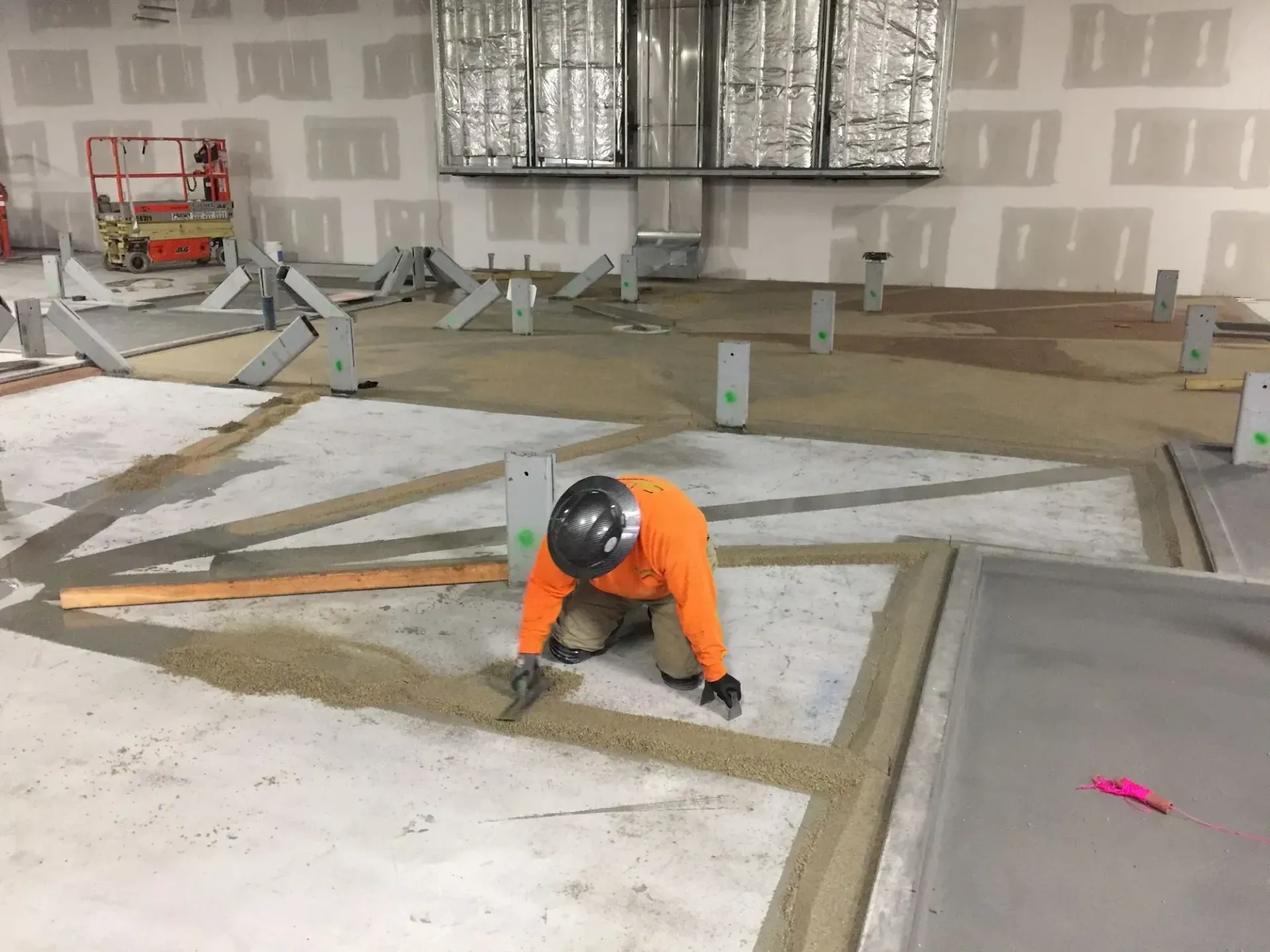 A man is kneeling on the floor of a building.