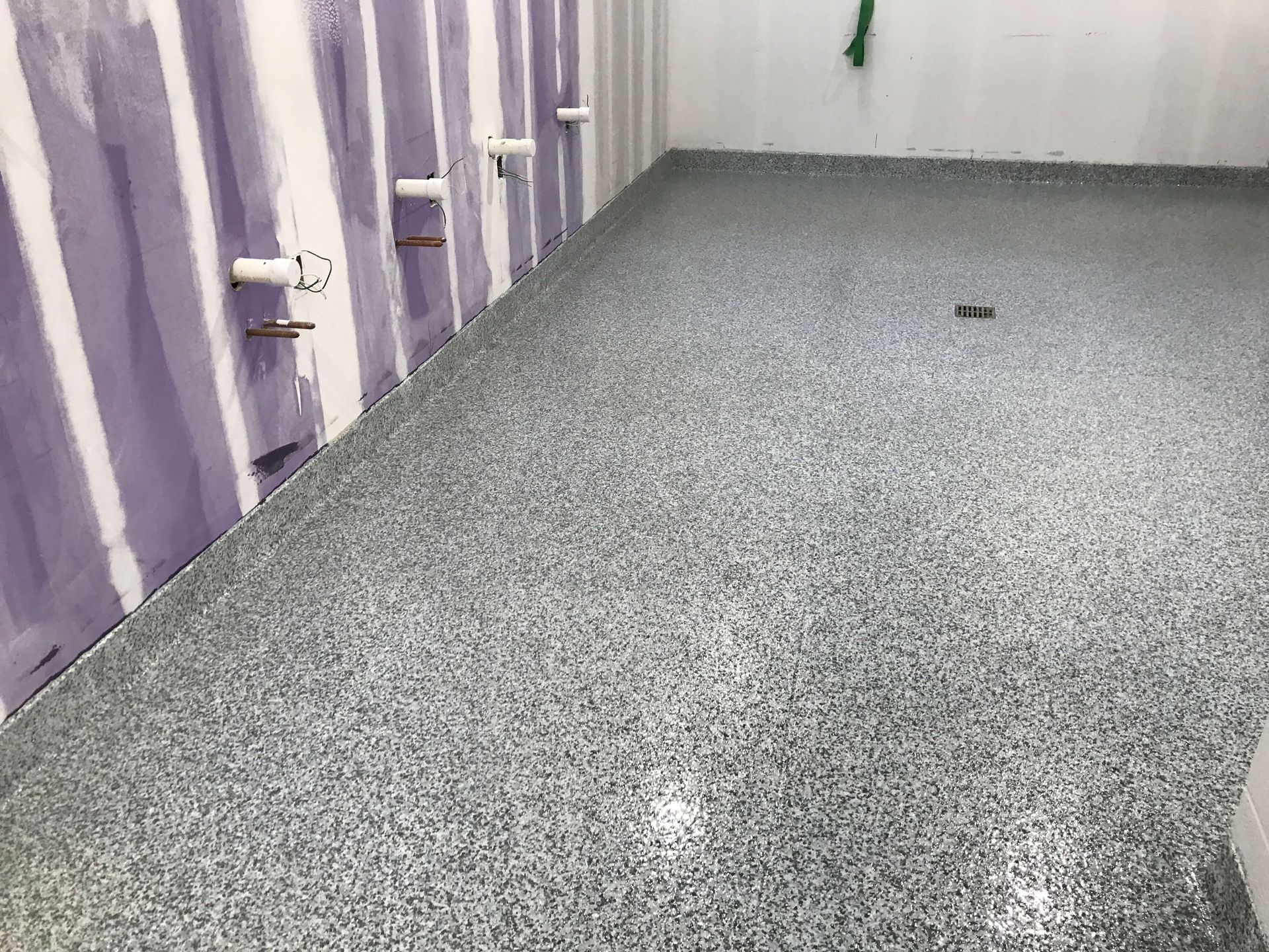 A room with a gray floor and purple walls.