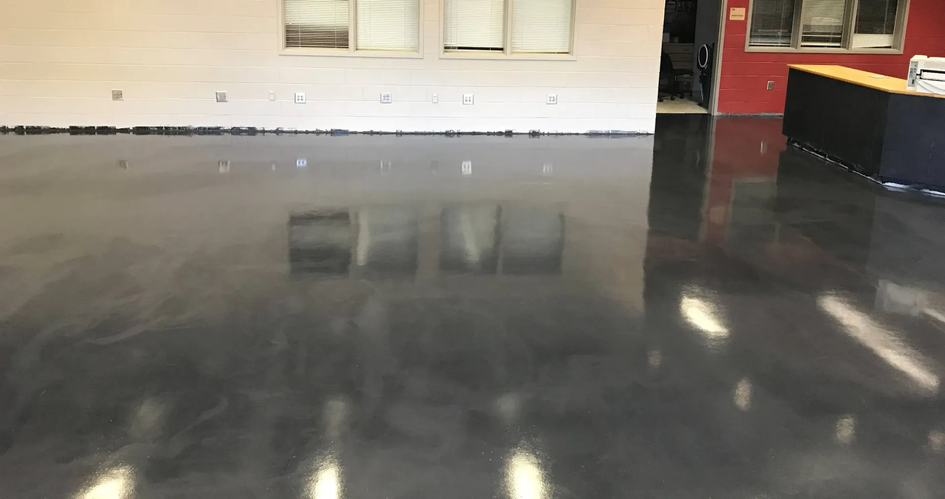 A large room with a black floor and a white wall.