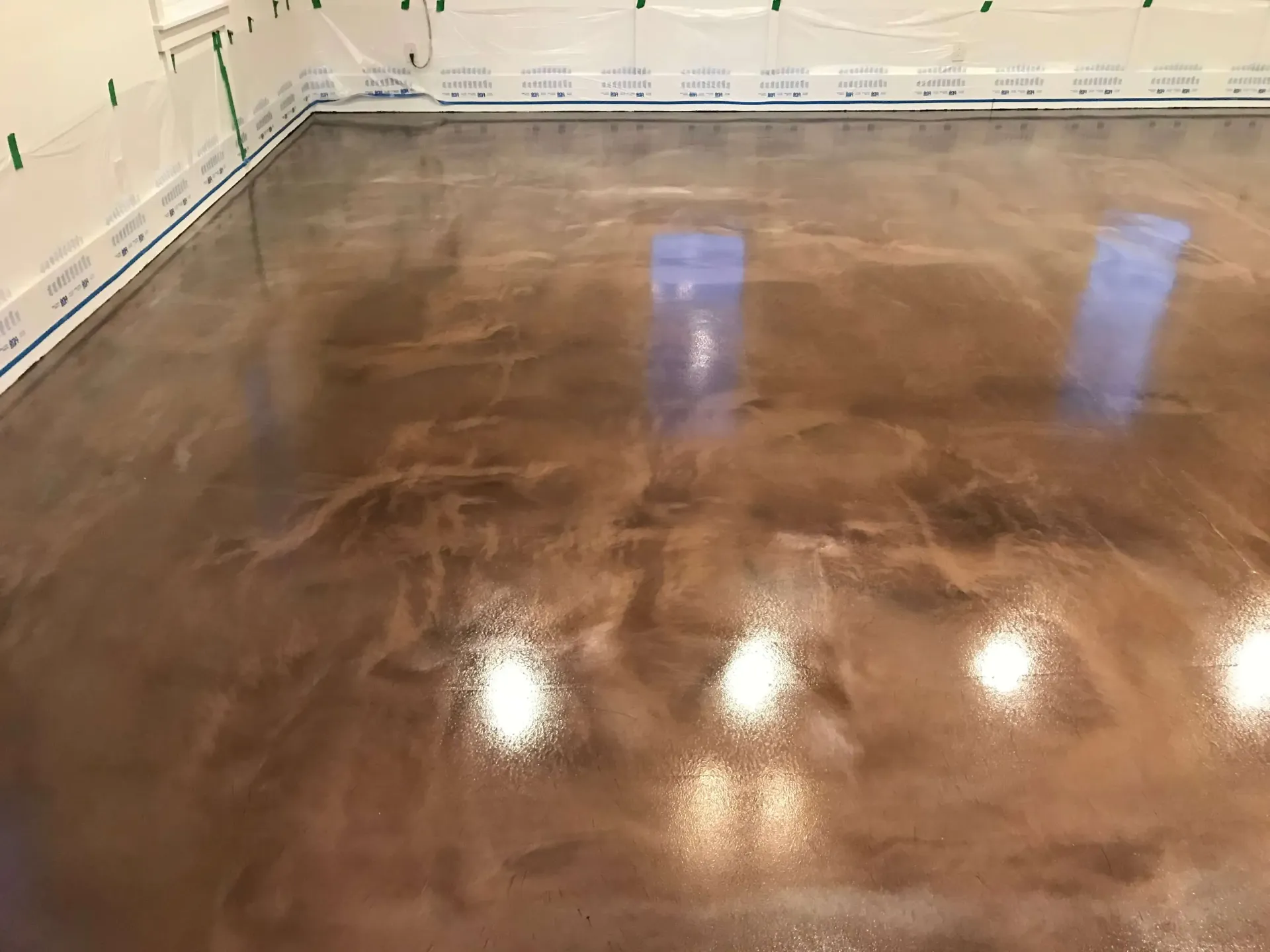 A shiny concrete floor in a room with a lot of lights on it.