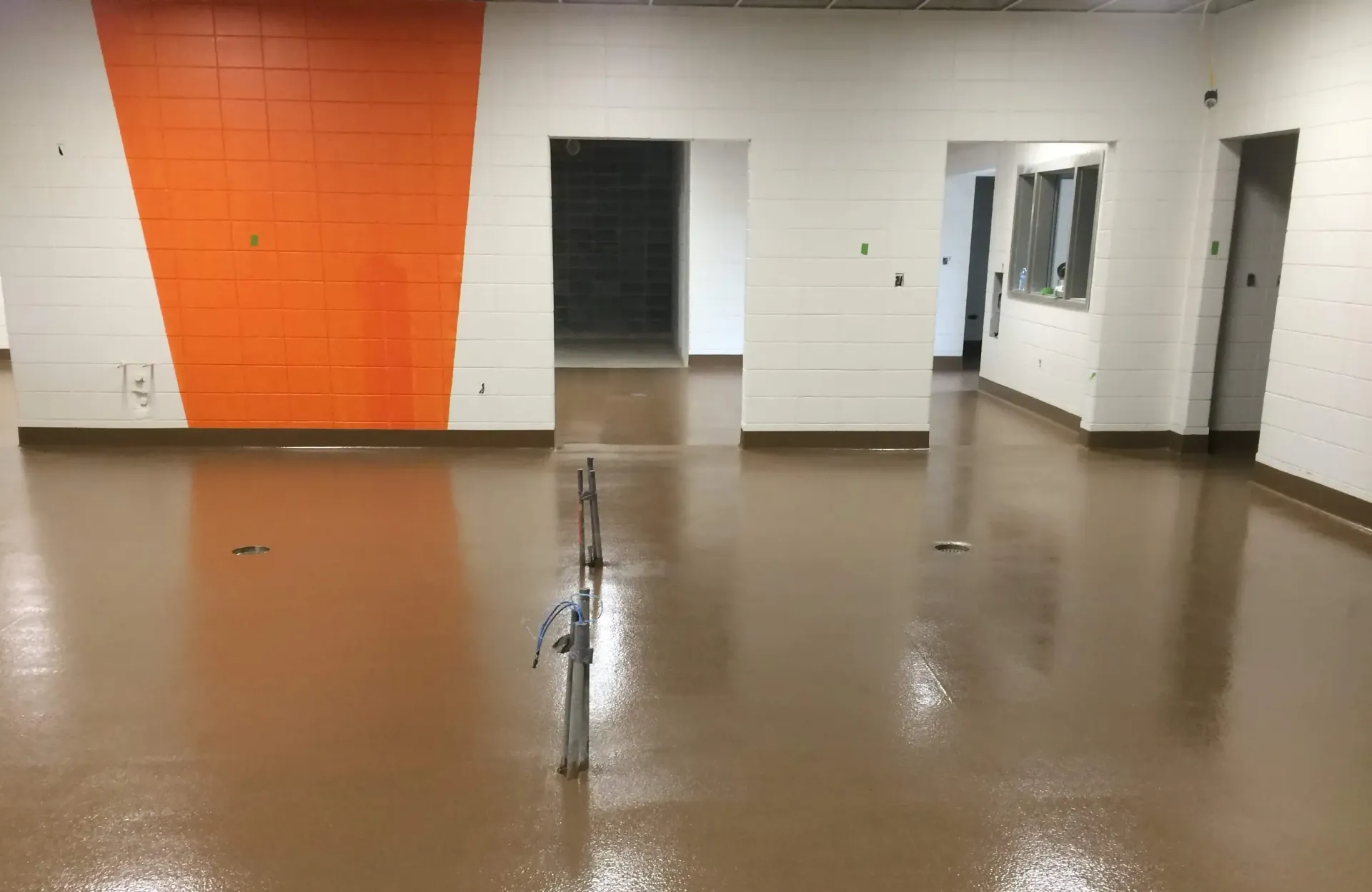 A large room with a brown floor and white walls.
