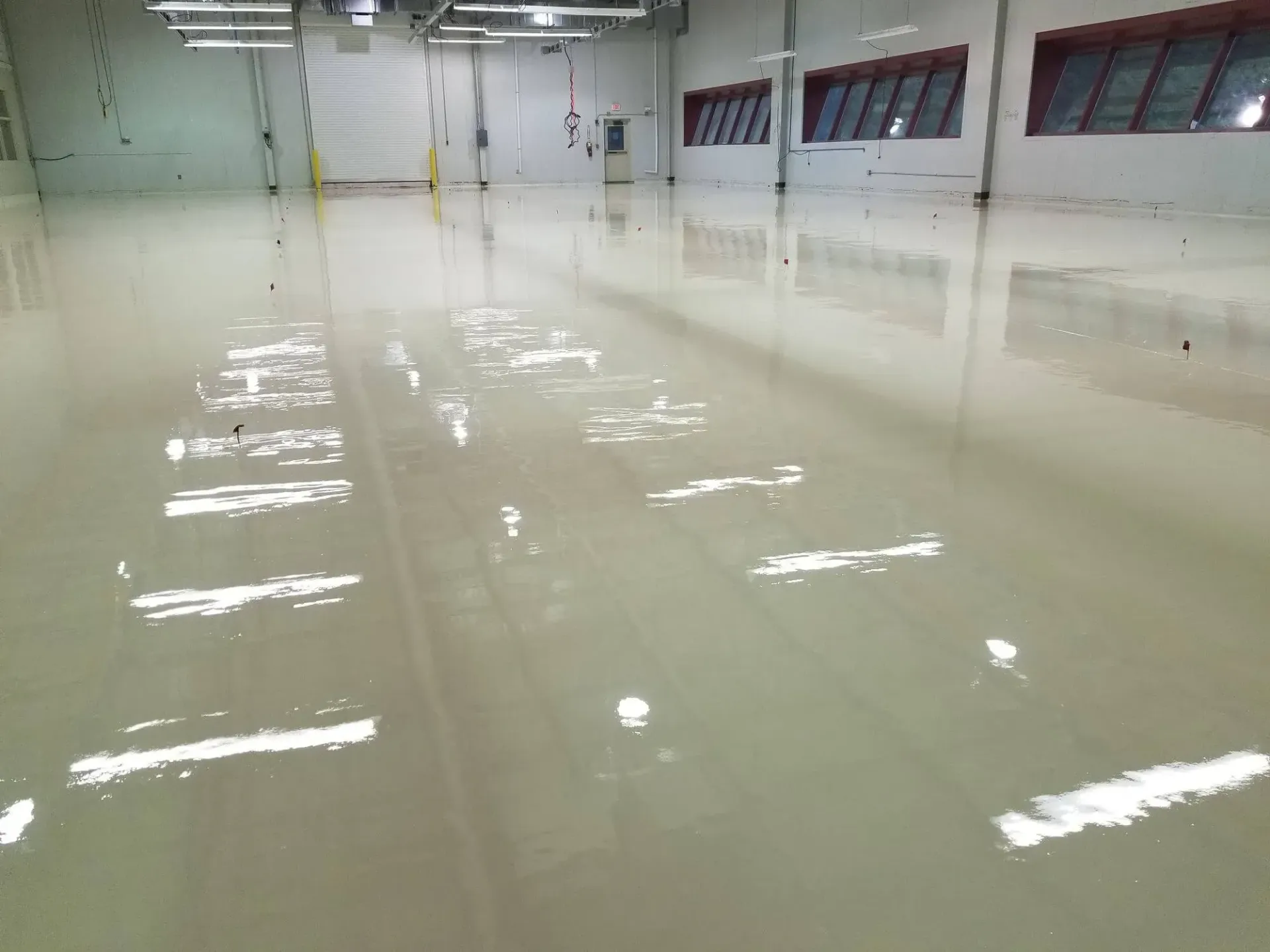 A large warehouse with a shiny floor and lots of windows.
