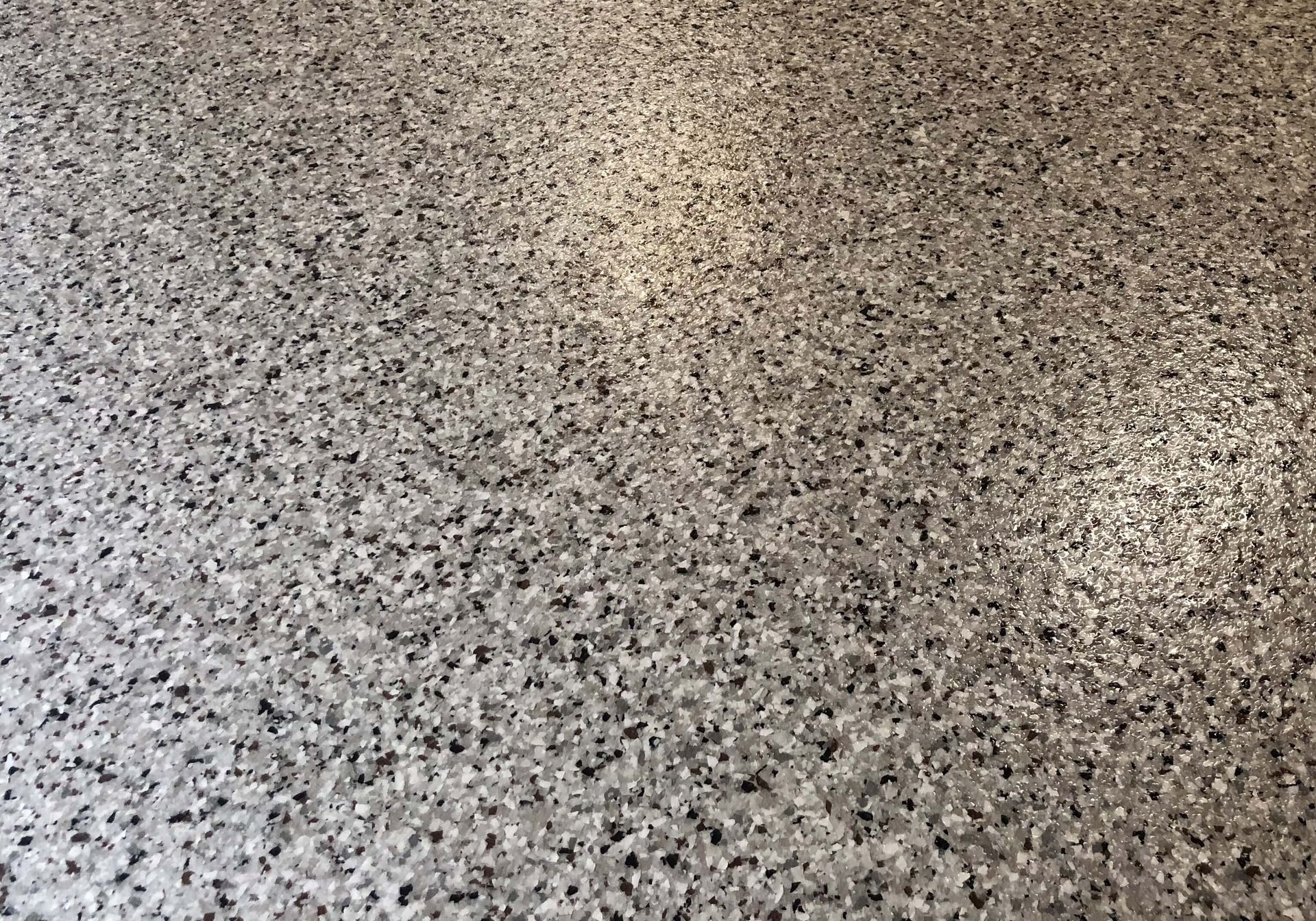 A close up of a gray floor with a lot of small stones on it.
