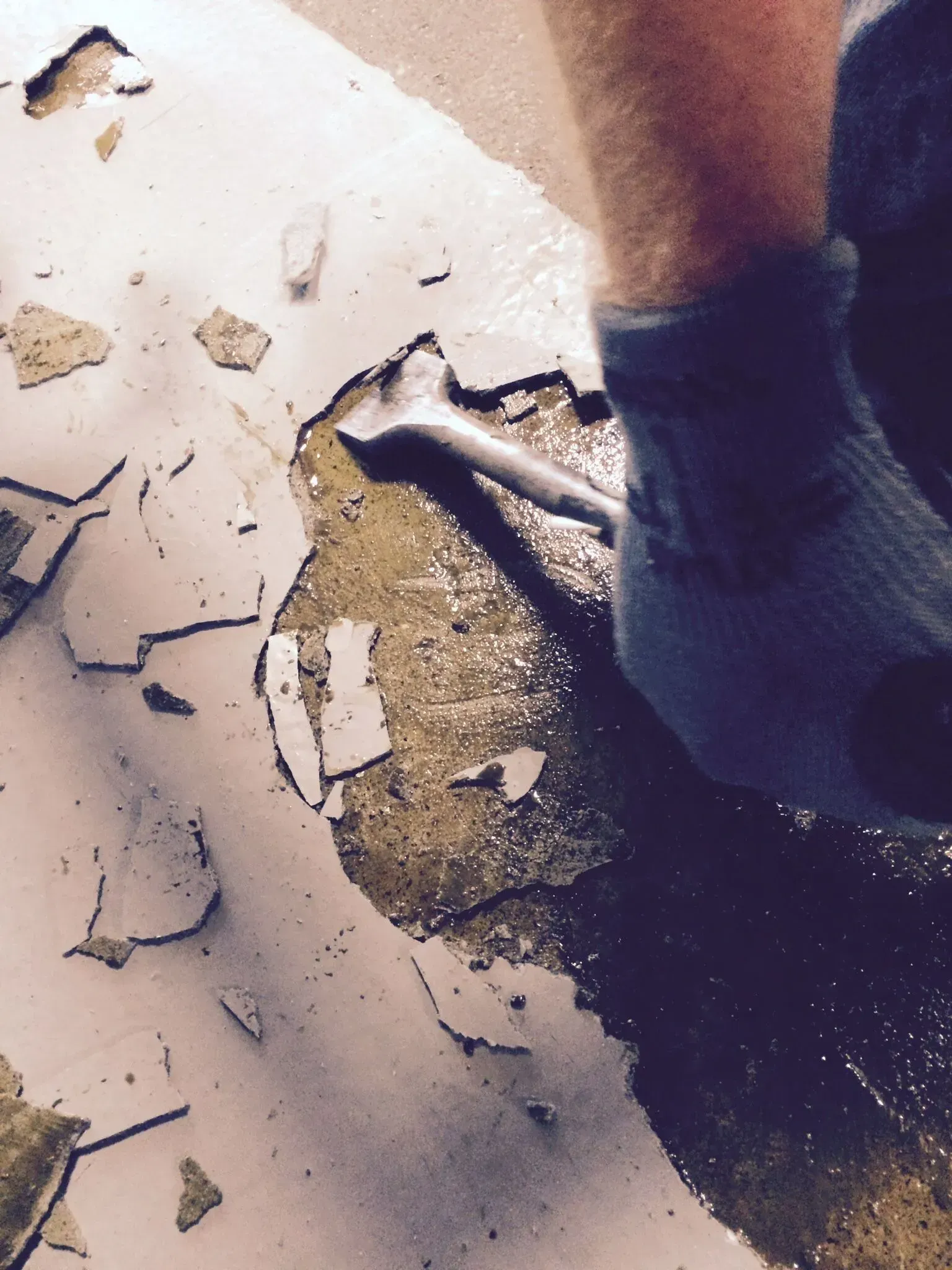 A person is using a wrench to remove a piece of concrete