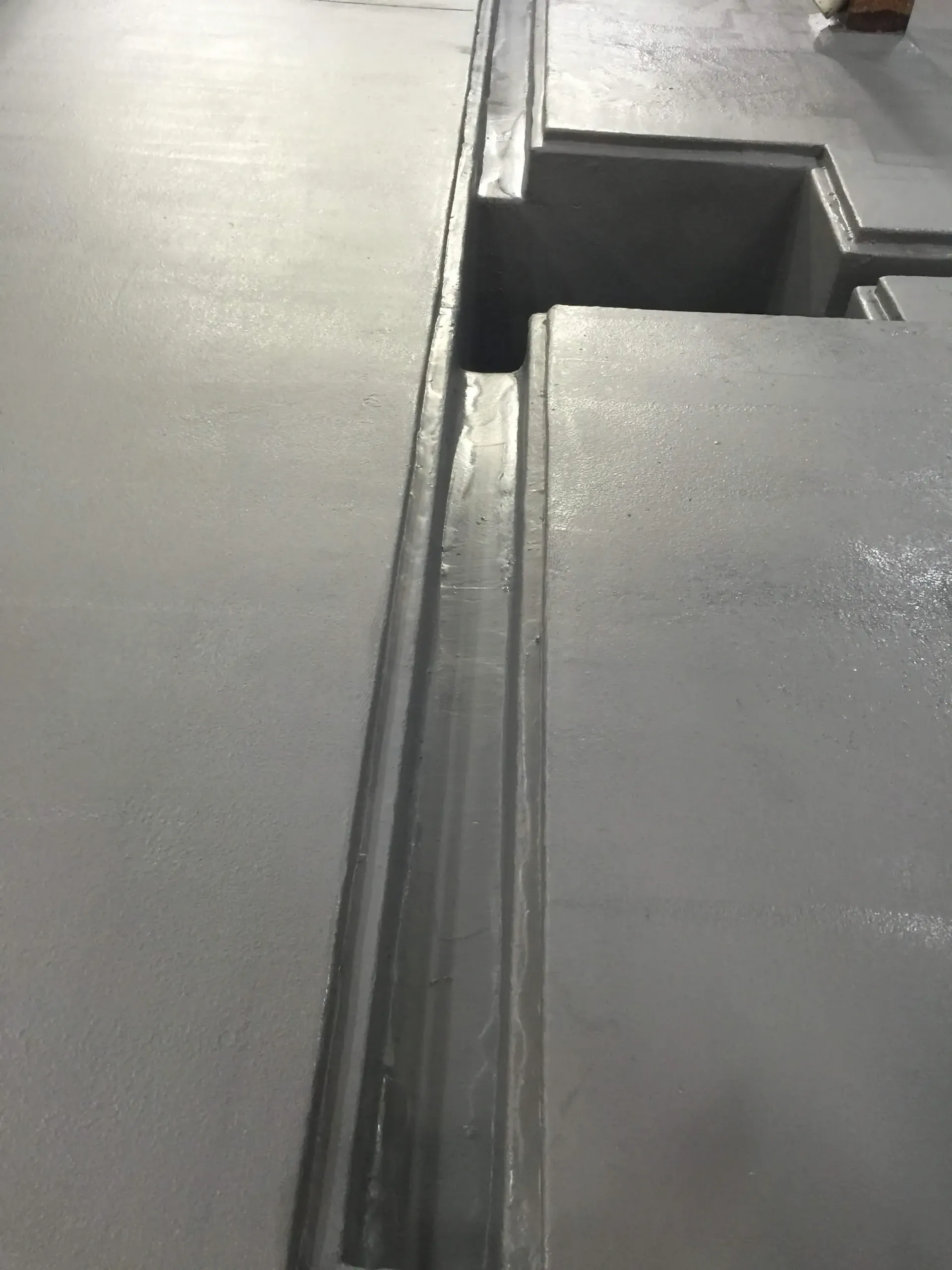 A concrete floor with a drain in the middle of it.
