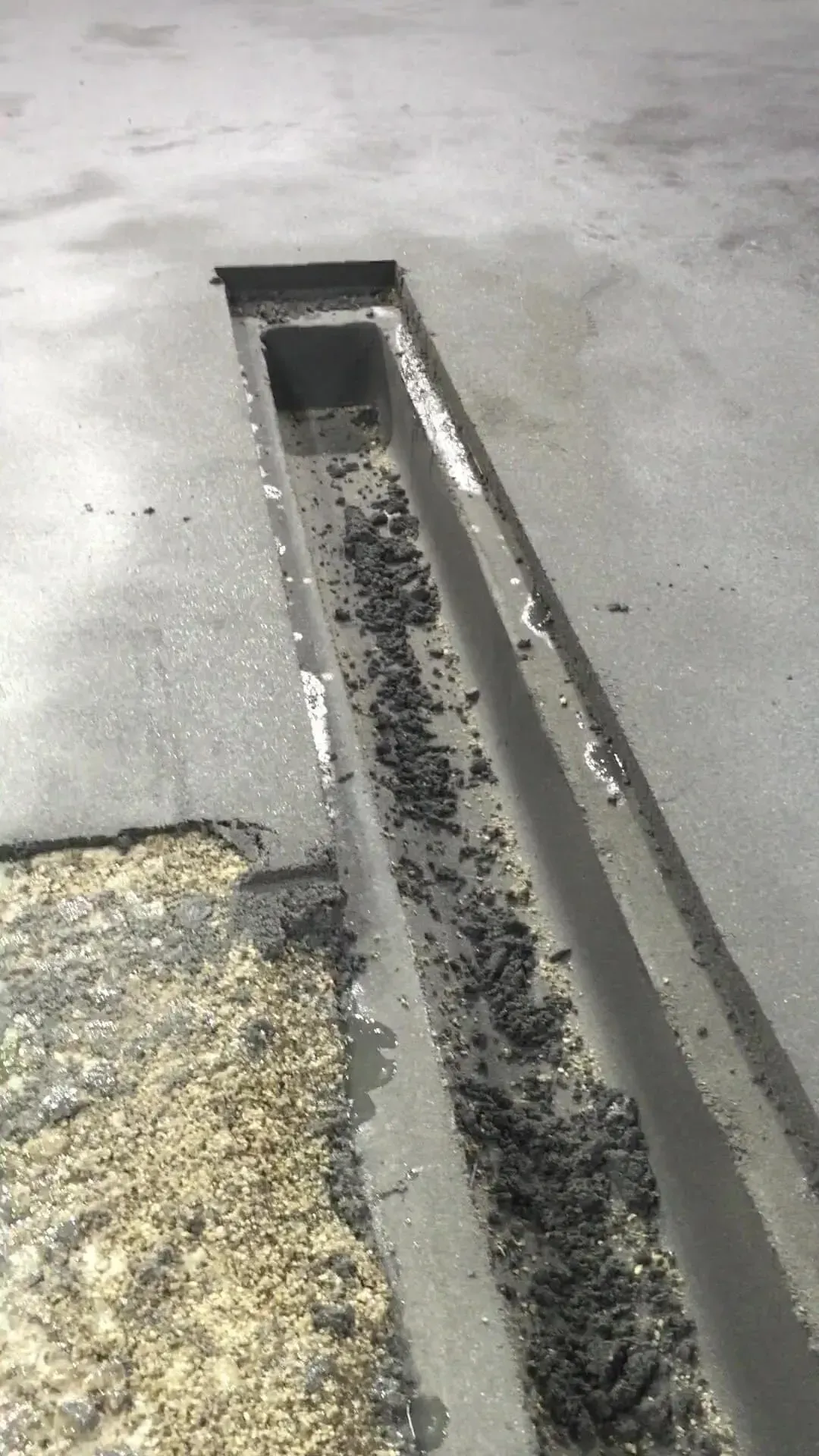 A close up of a drain on a concrete floor.
