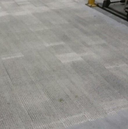 A close up of a concrete floor with a yellow pole in the background.