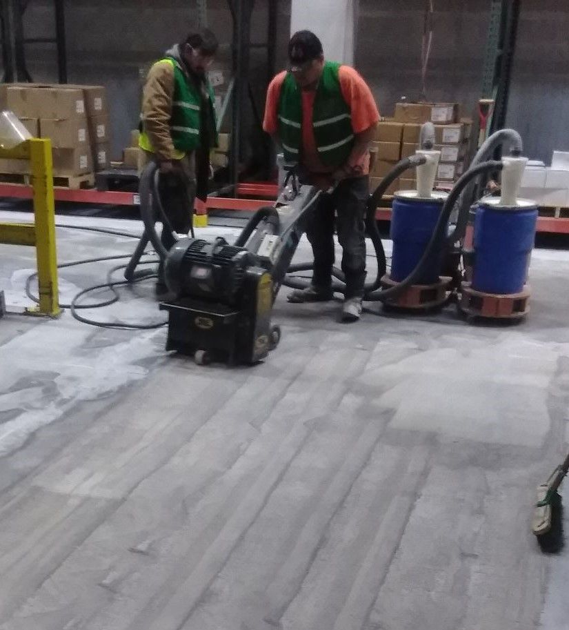 A man is using a vacuum cleaner on a wooden floor