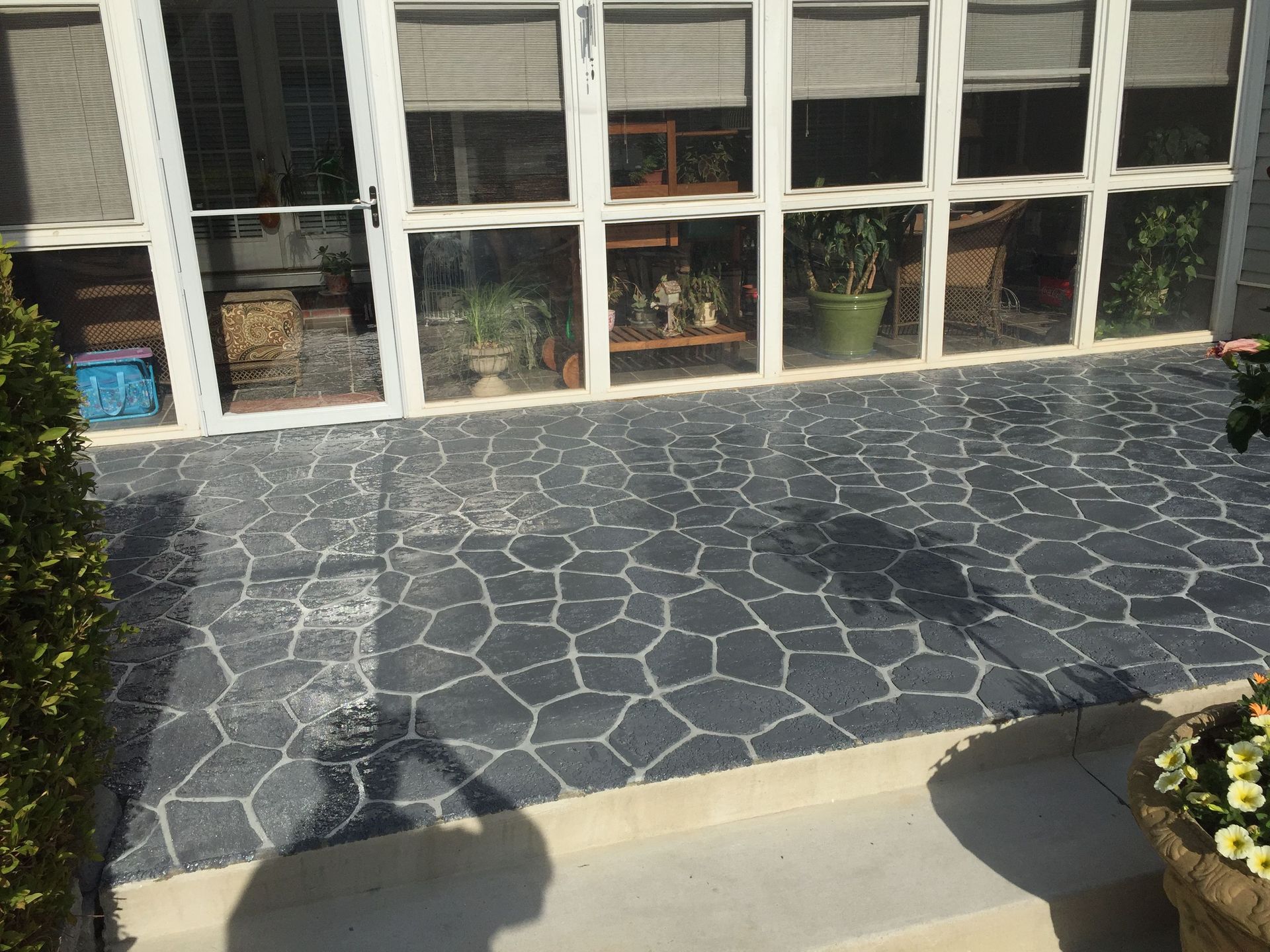 A patio with black and white decorative concrete.