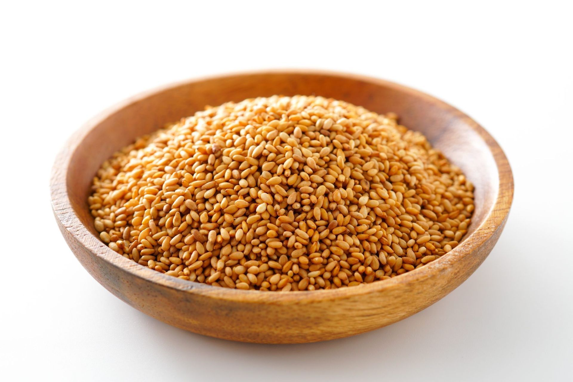 Wooden bowl filled with sesame seeds