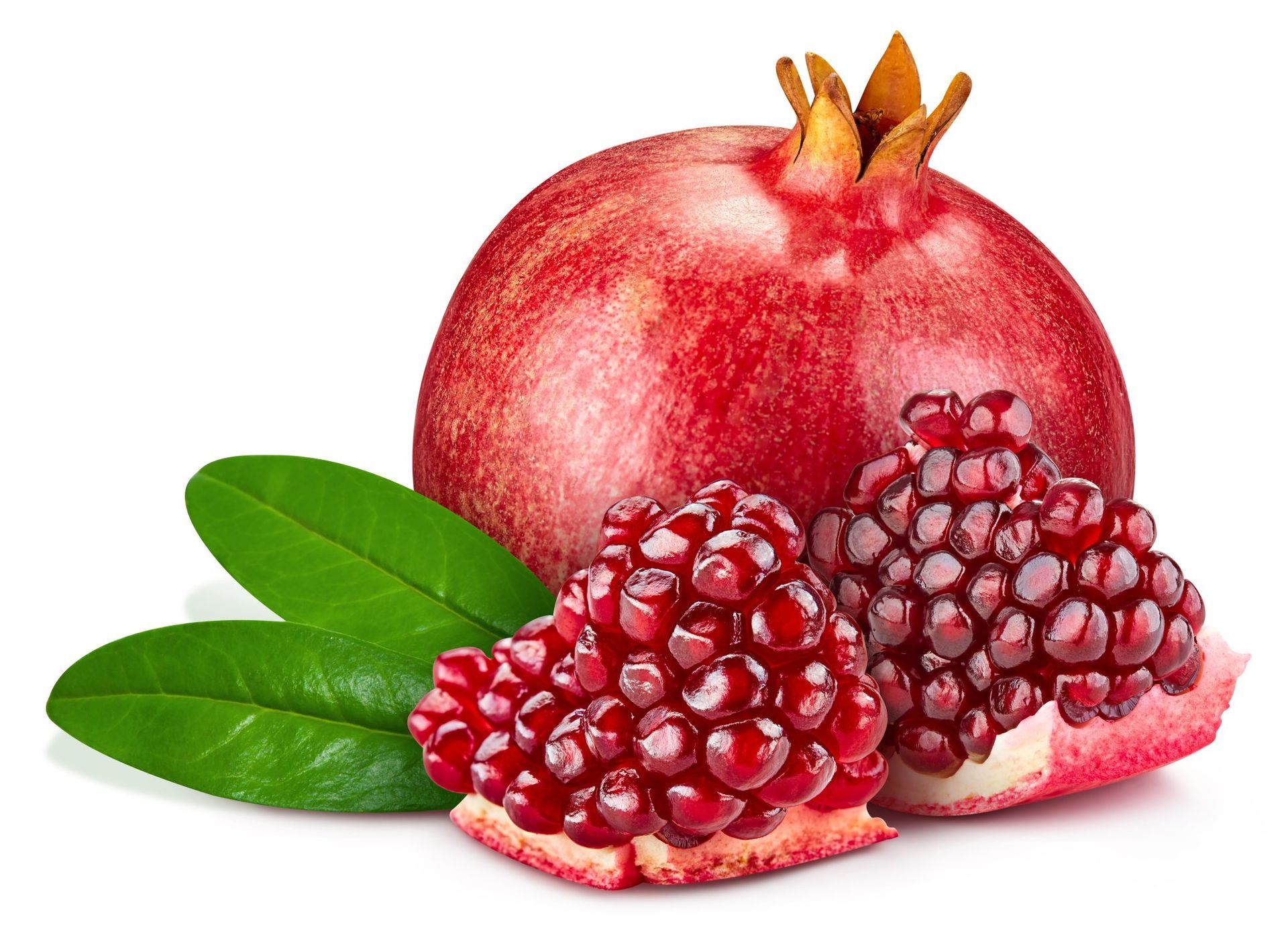 Pomegranate with green leaves and two halved pomegranates showing bright red seeds