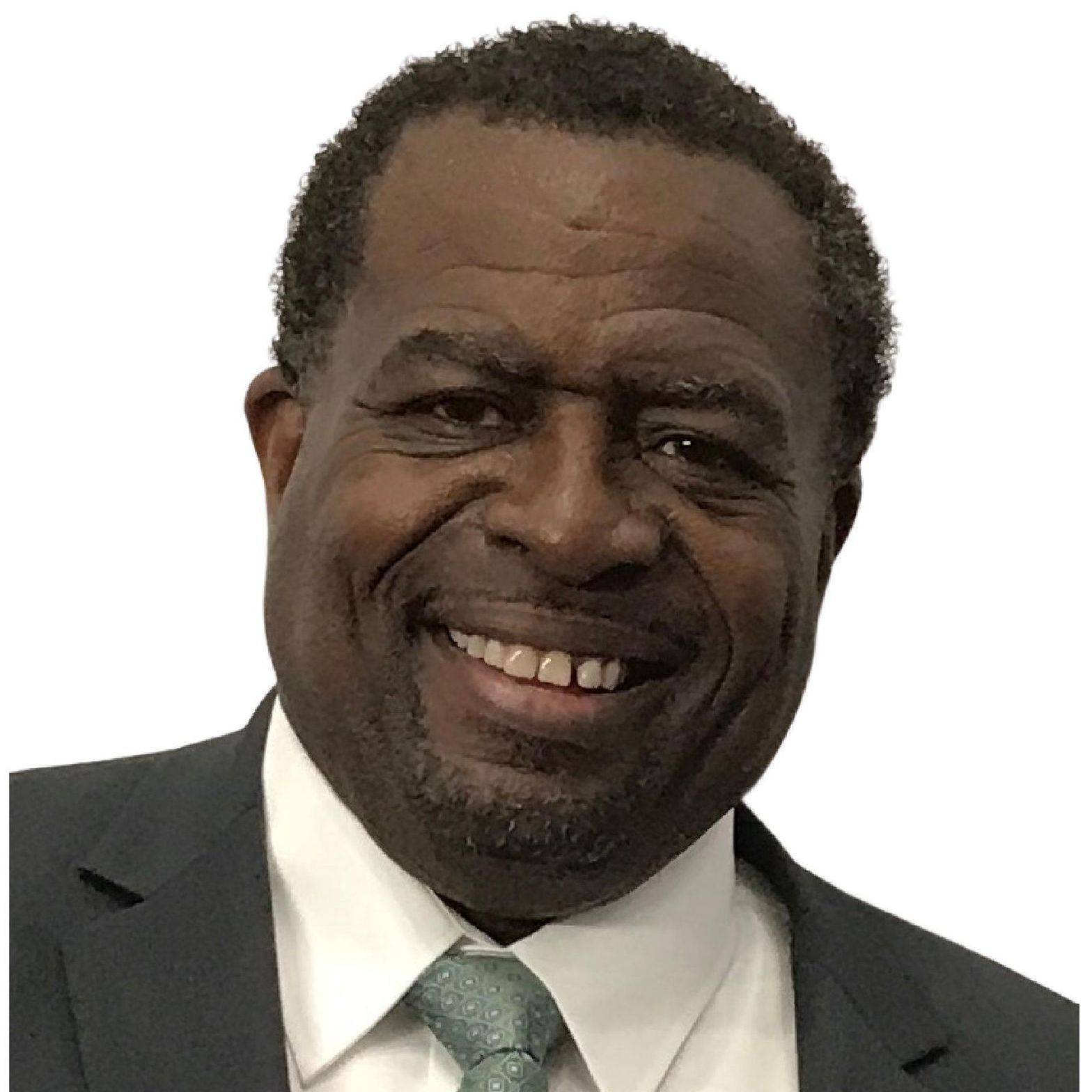 Smiling man in a dark suit, white shirt, and light green tie on a white background