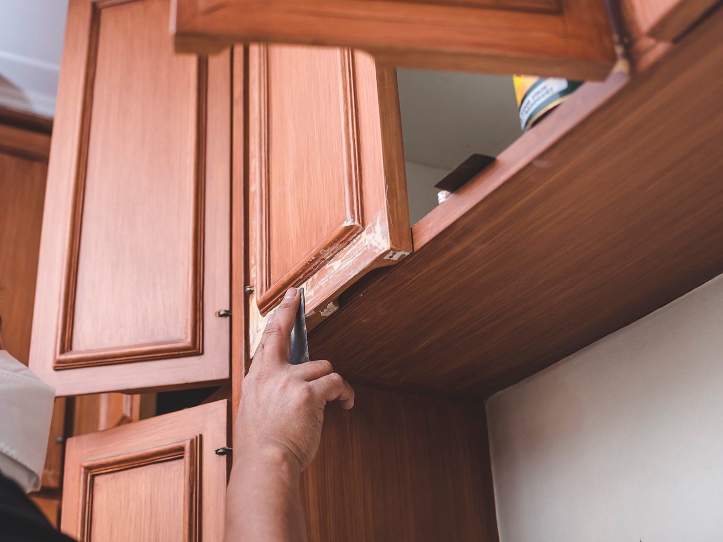 man sandpapers panels wall cabinet filled