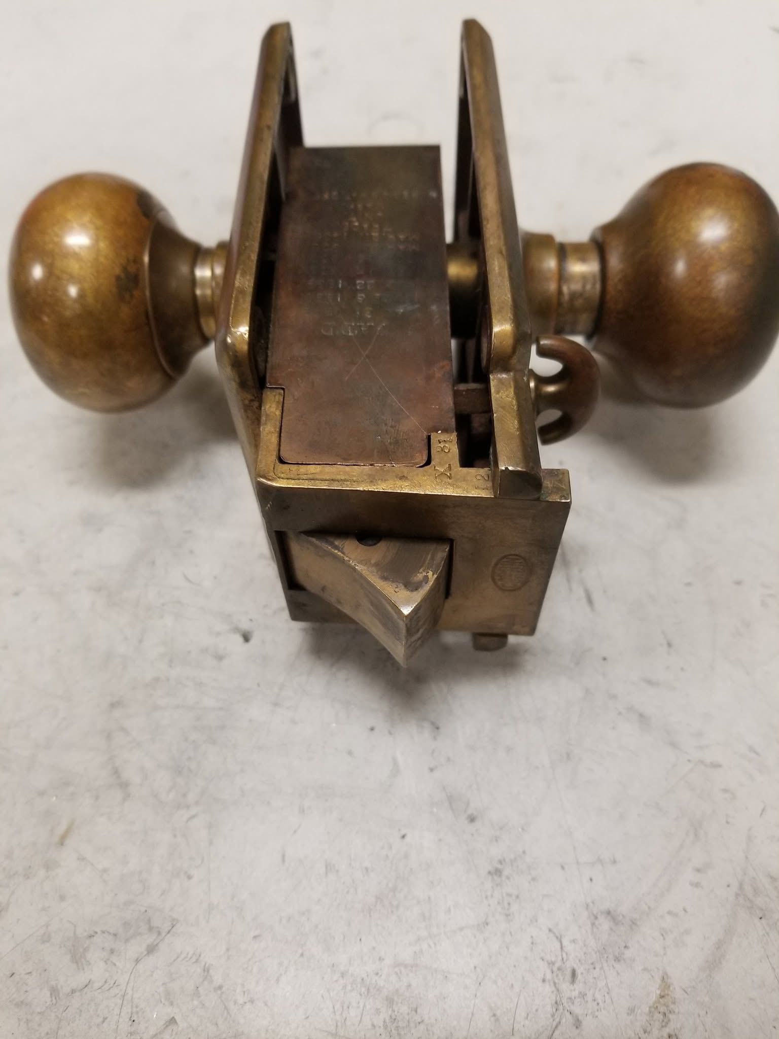 Vintage metal hand plane with wooden handles on a white surface