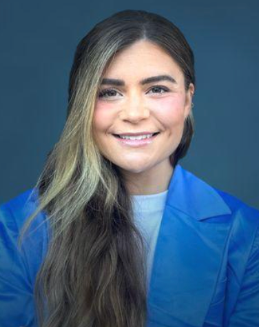 Smiling person in a blue blazer against a dark blue background